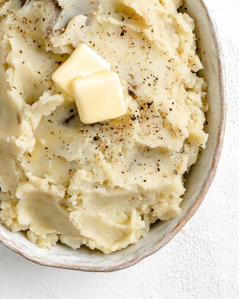 completed instant pot garlic mashed potatoes in a baking dish against a white background