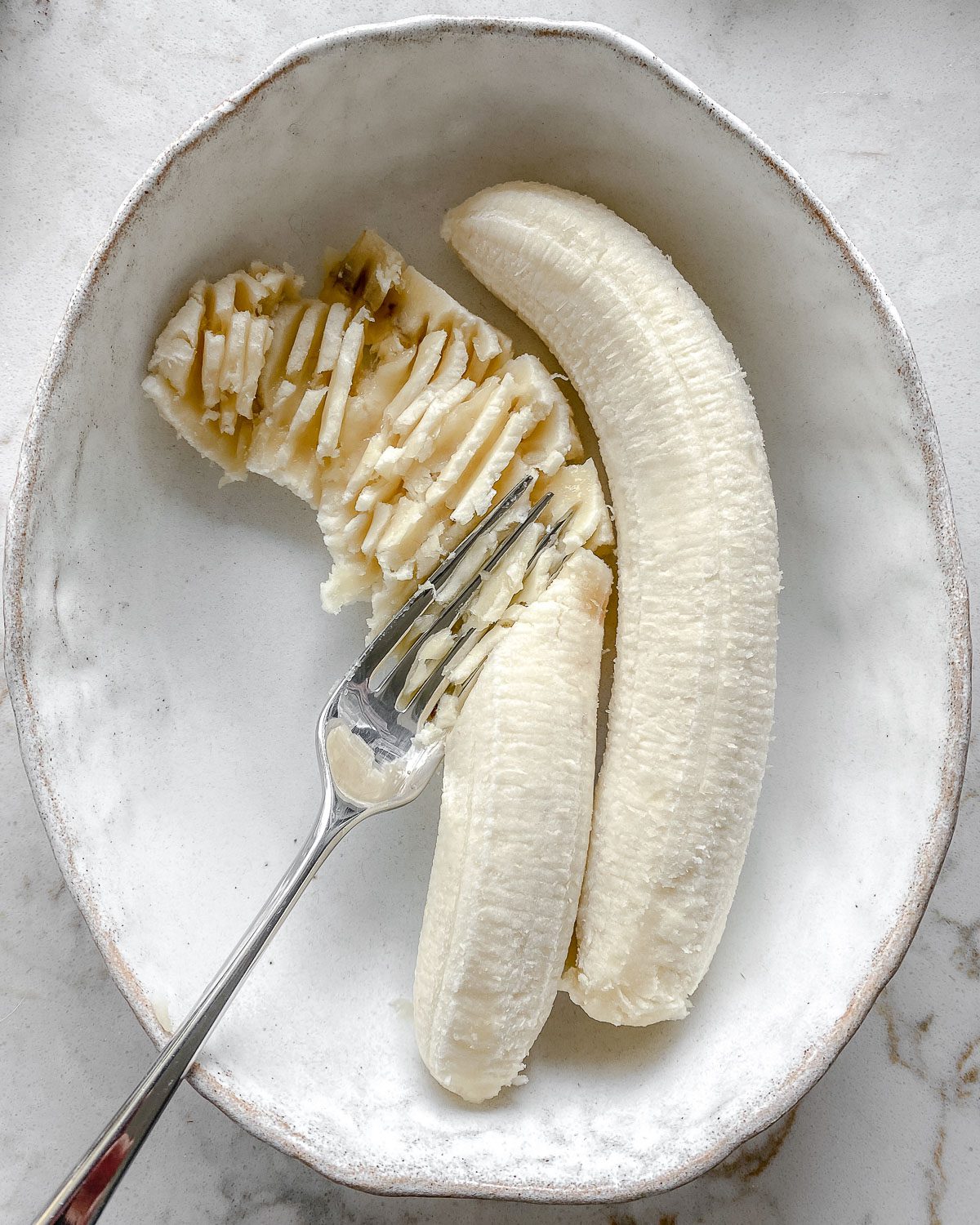 process of mashing banana with a fork