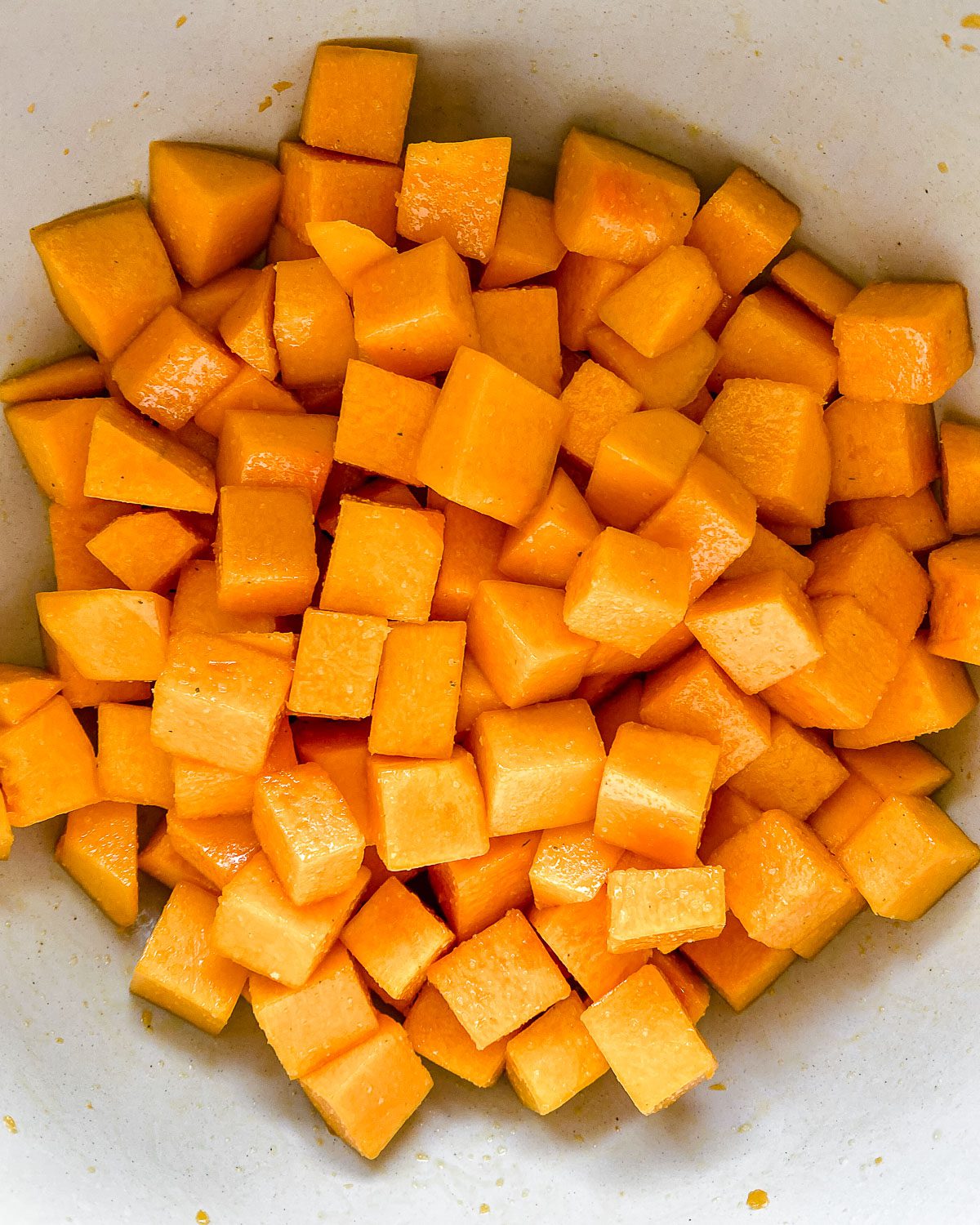 Process shot showing diced butternut squash in a bowl.