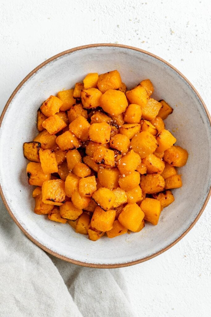 Completed Simple Air Fryer Butternut Squash in a white bowl against a white background.