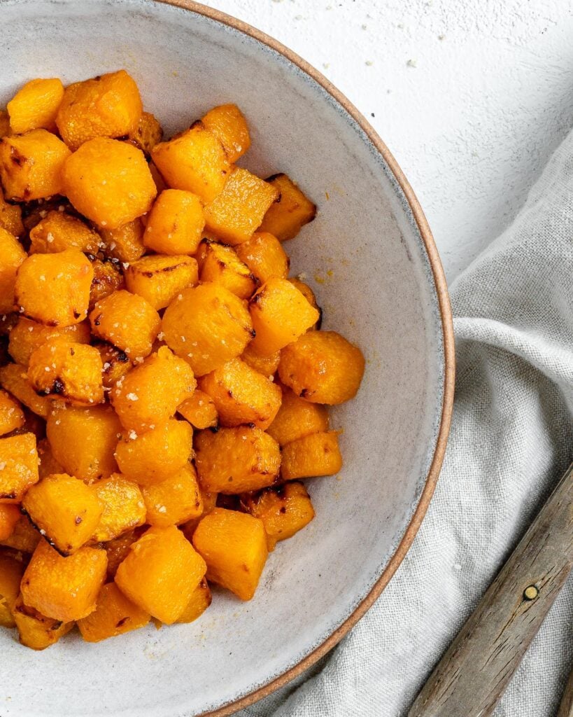 Completed Simple Air Fryer Butternut Squash in a white bowl against a white background.