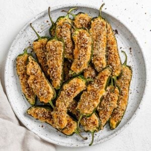 completed Vegan Jalapeno Poppers on a white speckled plate against a white background