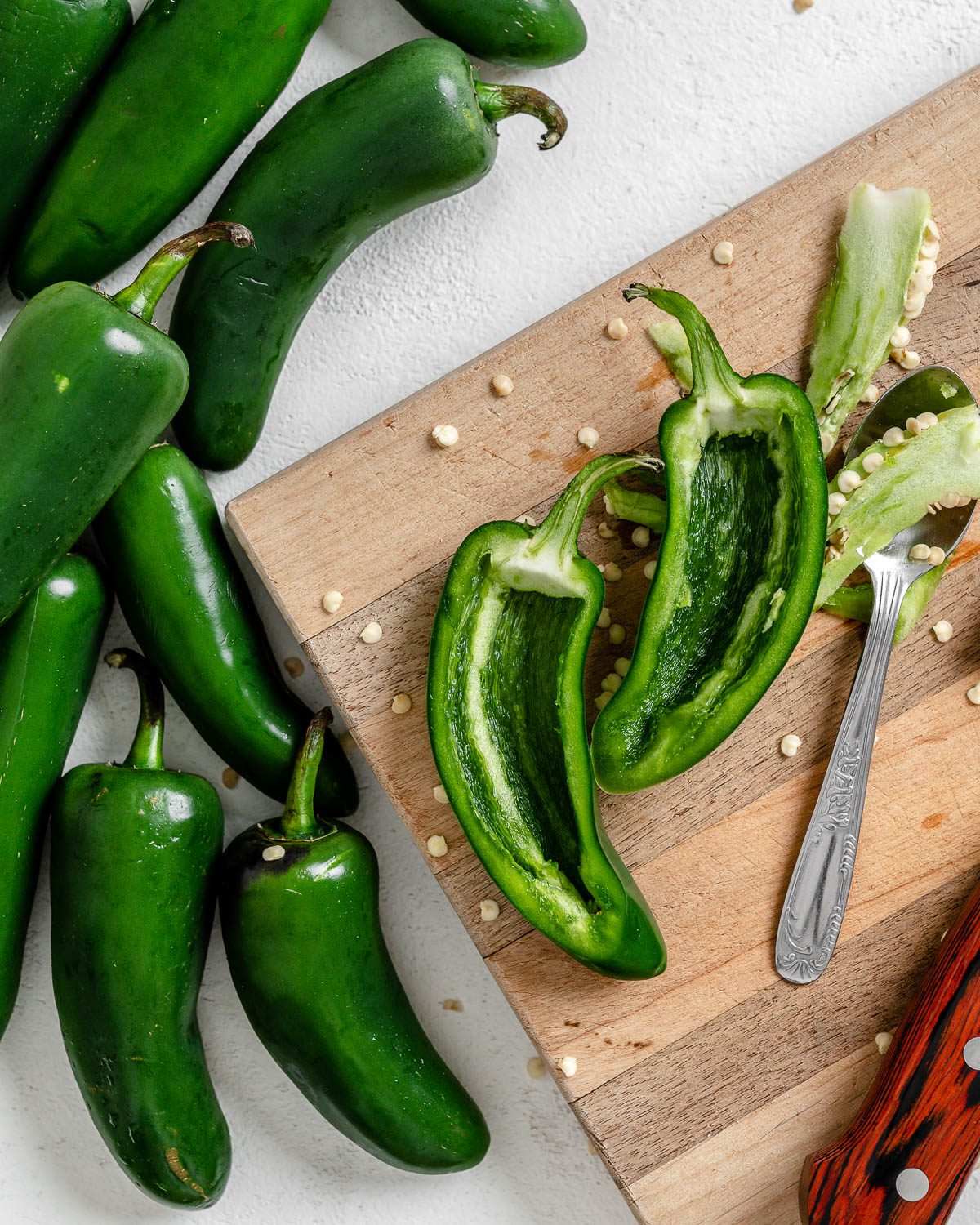 process of de-seeding jalapenos onto a cutting board