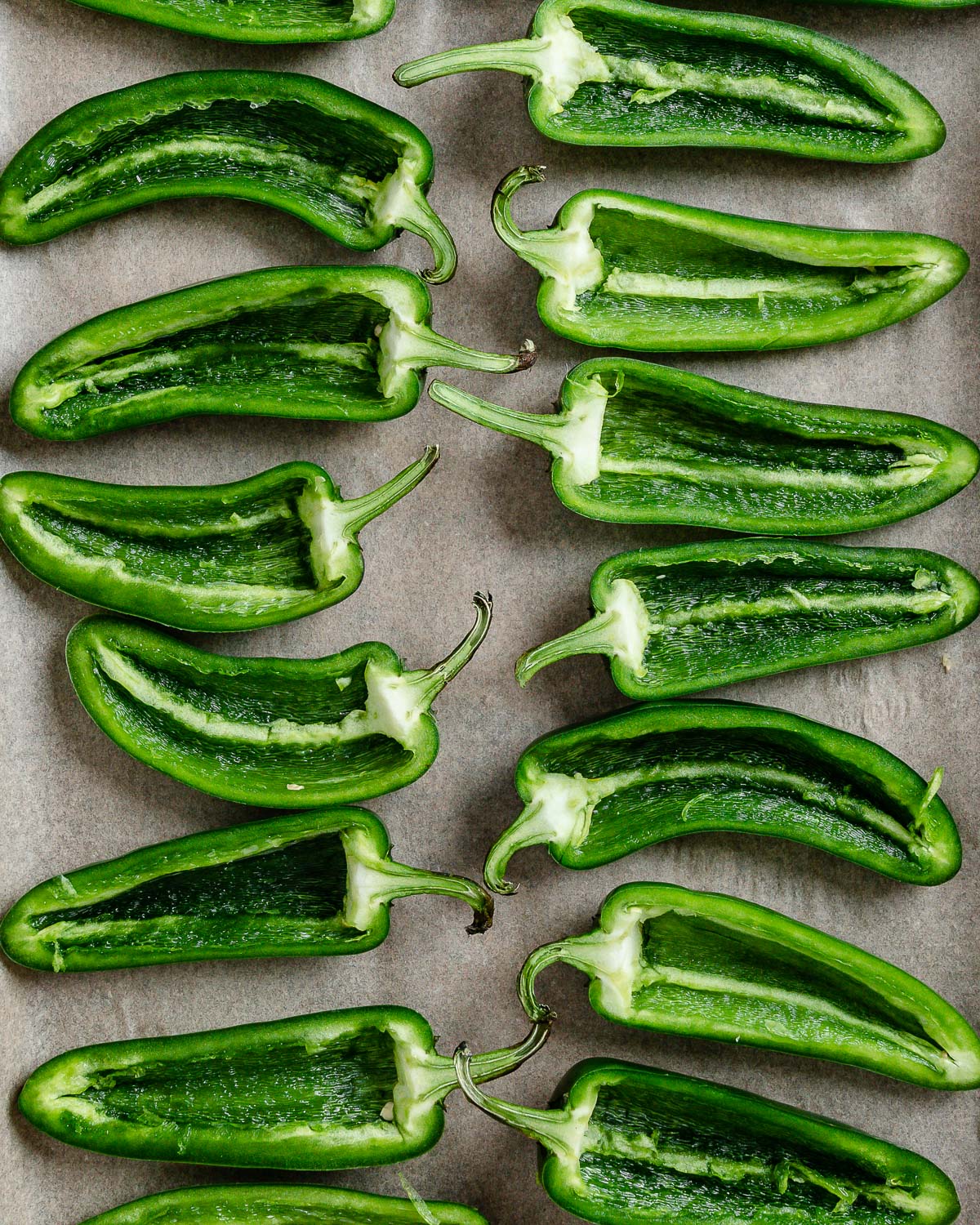 jalapenos lined up on a baking tray