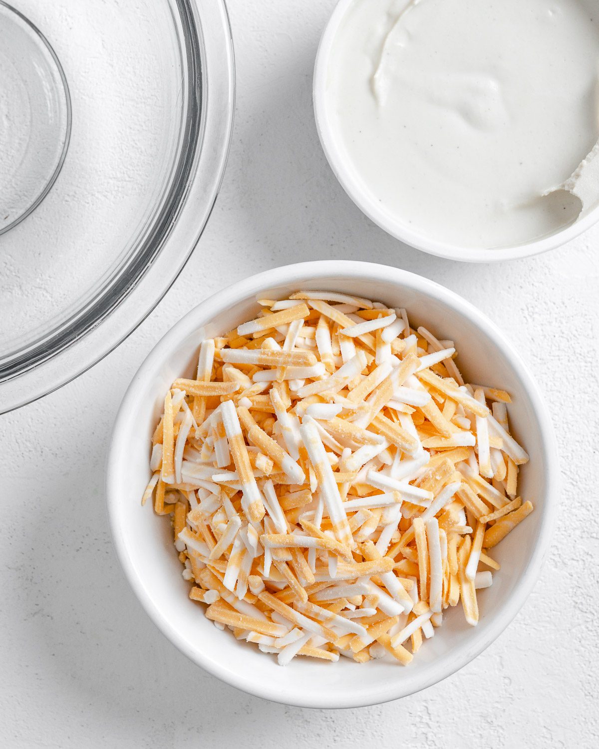 ingredients for flour mixture separated into white and clear bowls against white surface