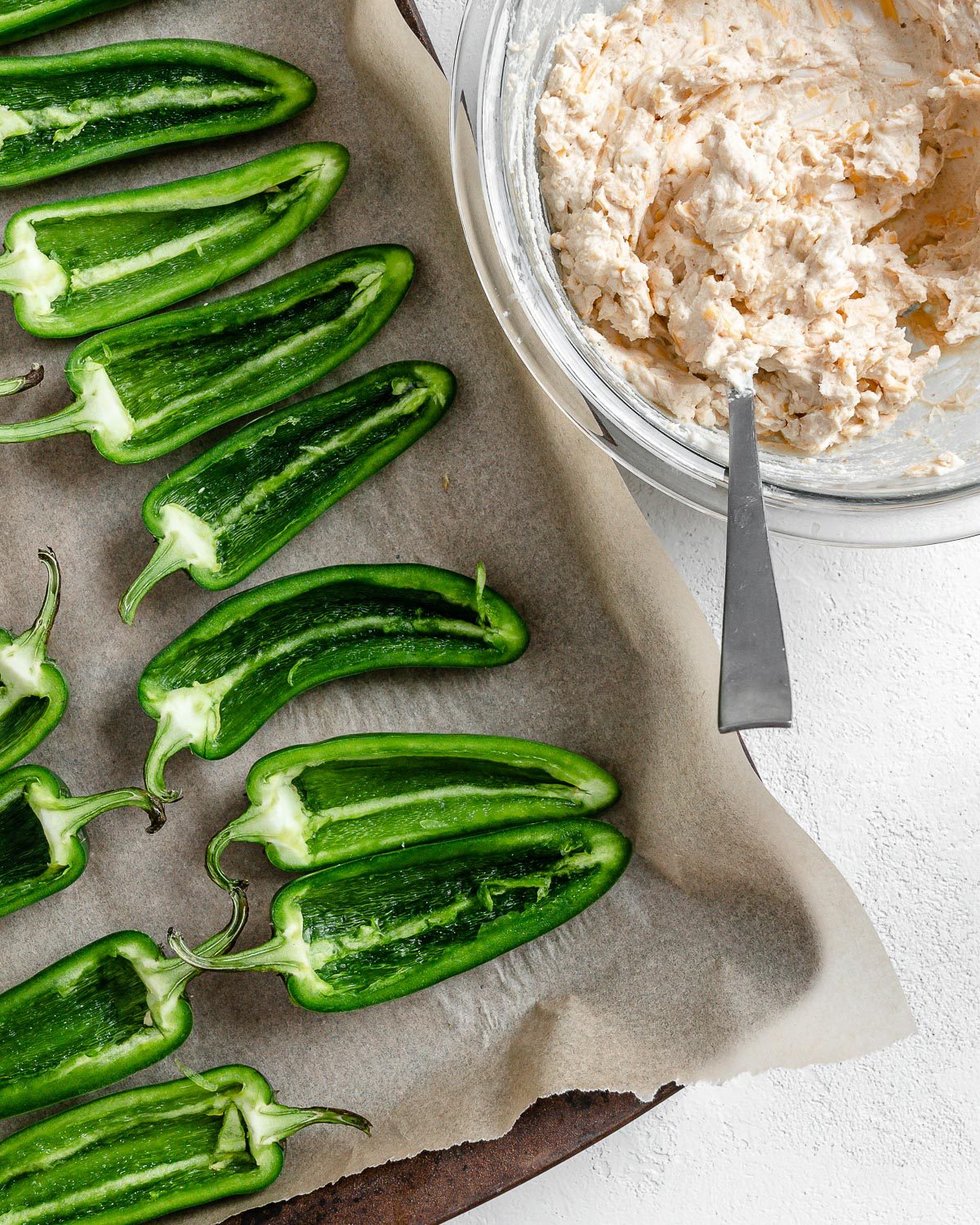 process of apply flour mixture to jalapeno poppers onto a baking tray