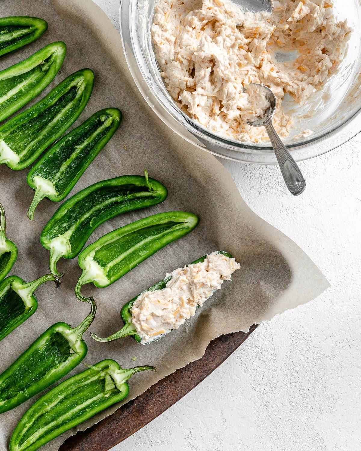 process of apply flour mixture to jalapeno poppers onto a baking tray