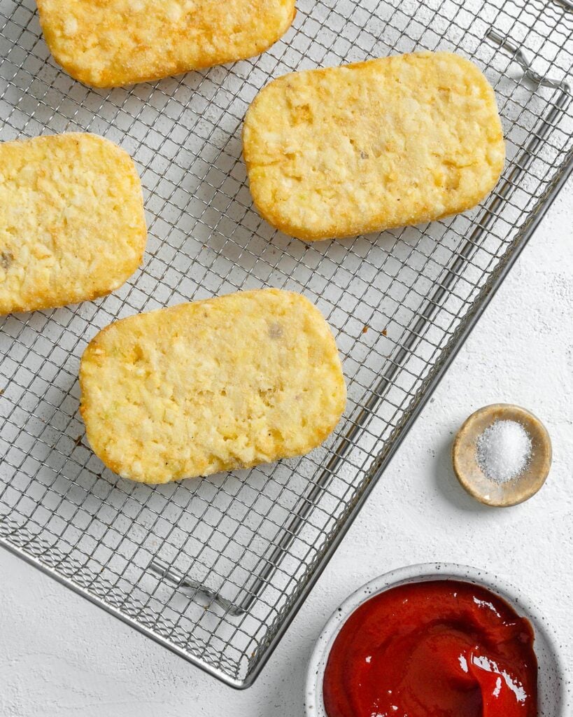 frozen patties on an air fryer tray against a white background