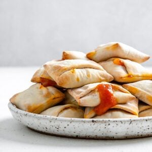 completed Air Fryer Pizza Rolls in a white speckled plate against a white background