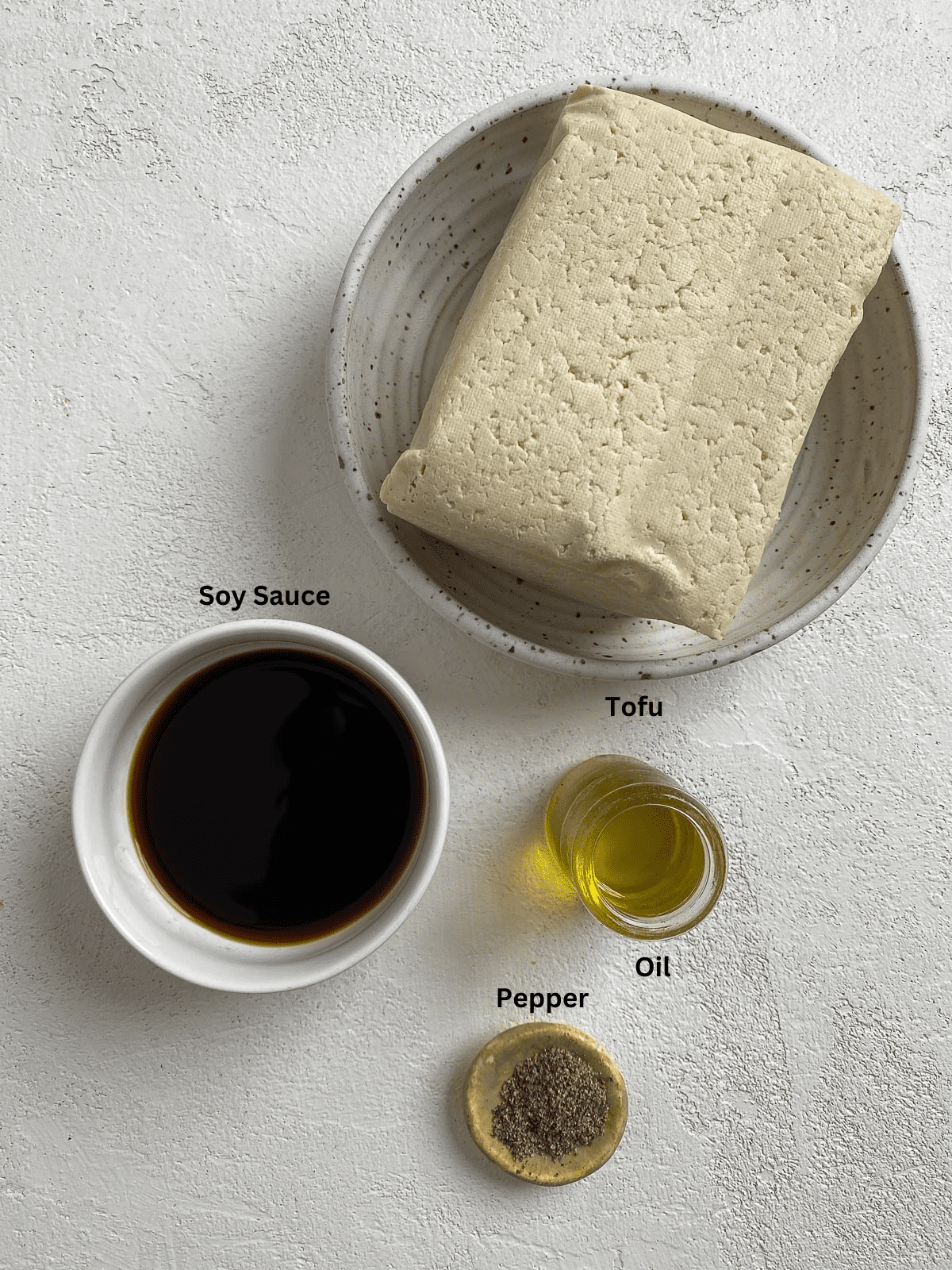 Ingredients measured out for air fryer tofu against a light surface.