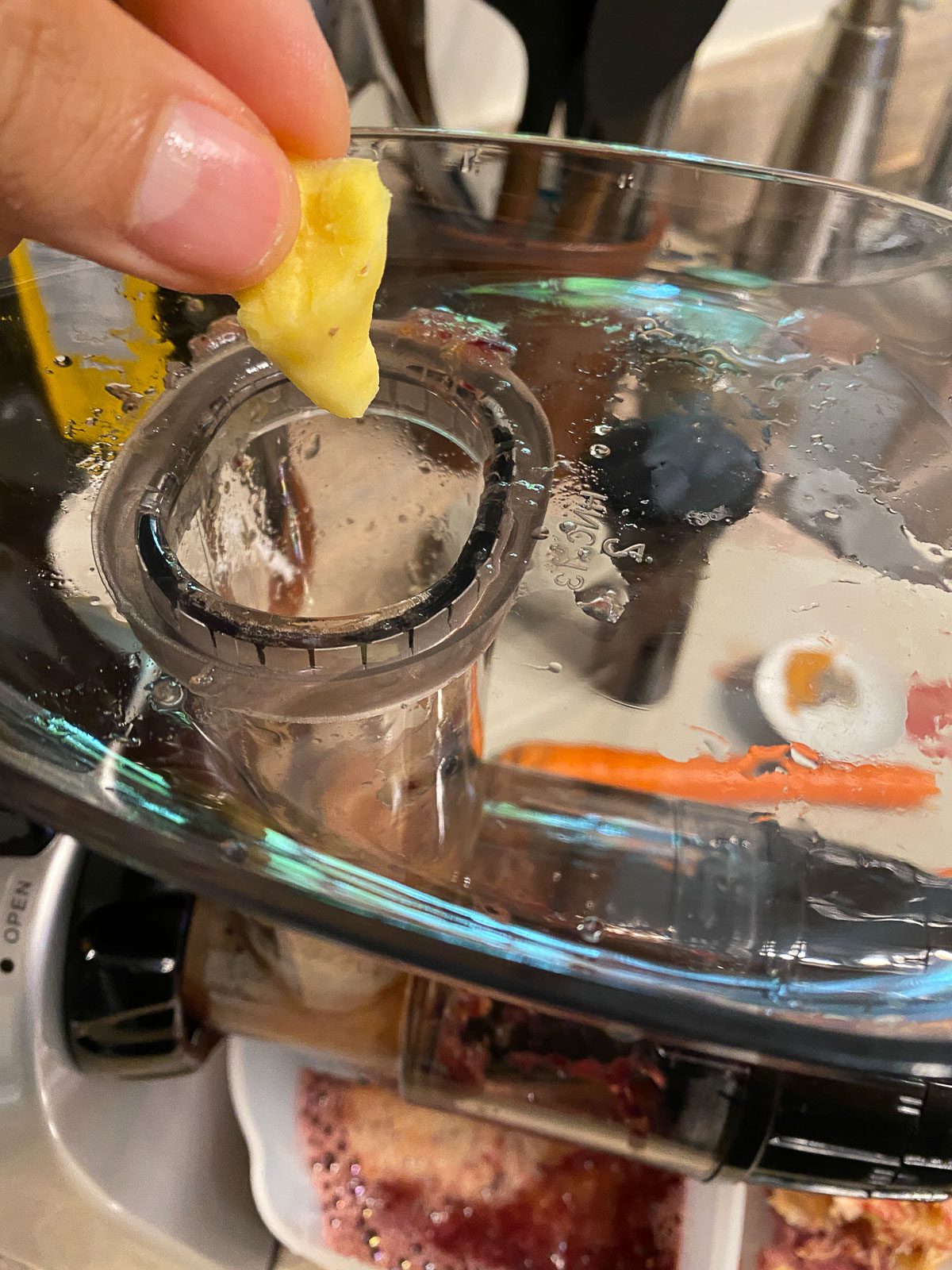 process of shot of adding ginger to juicer