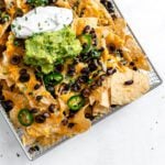 completed Vegan Air Fryer Nachos on air fryer tray against white surface