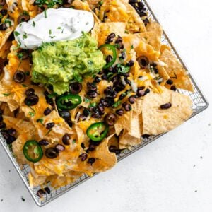 completed Vegan Air Fryer Nachos on air fryer tray against white surface
