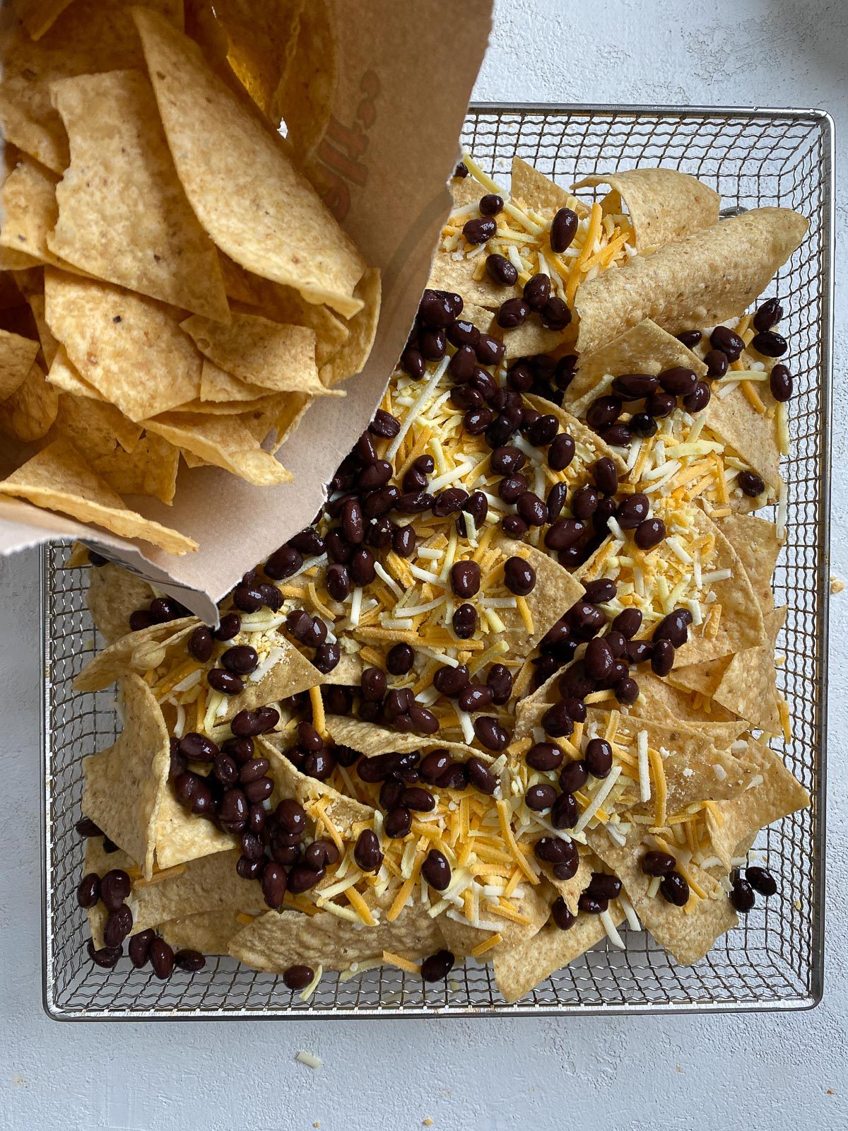 chips being poured onto air fryer rack