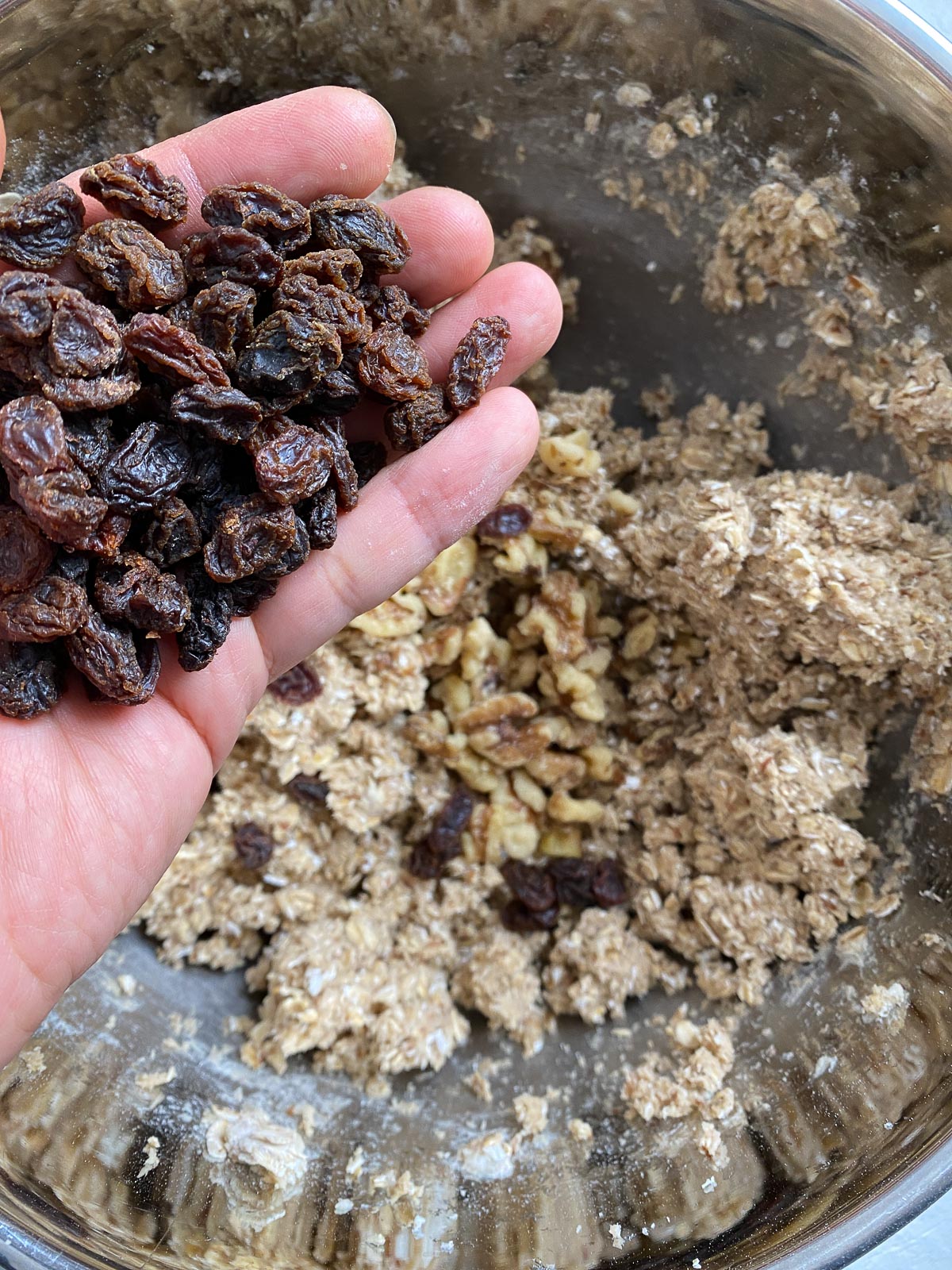 process shot of adding raisins to mixing bowl