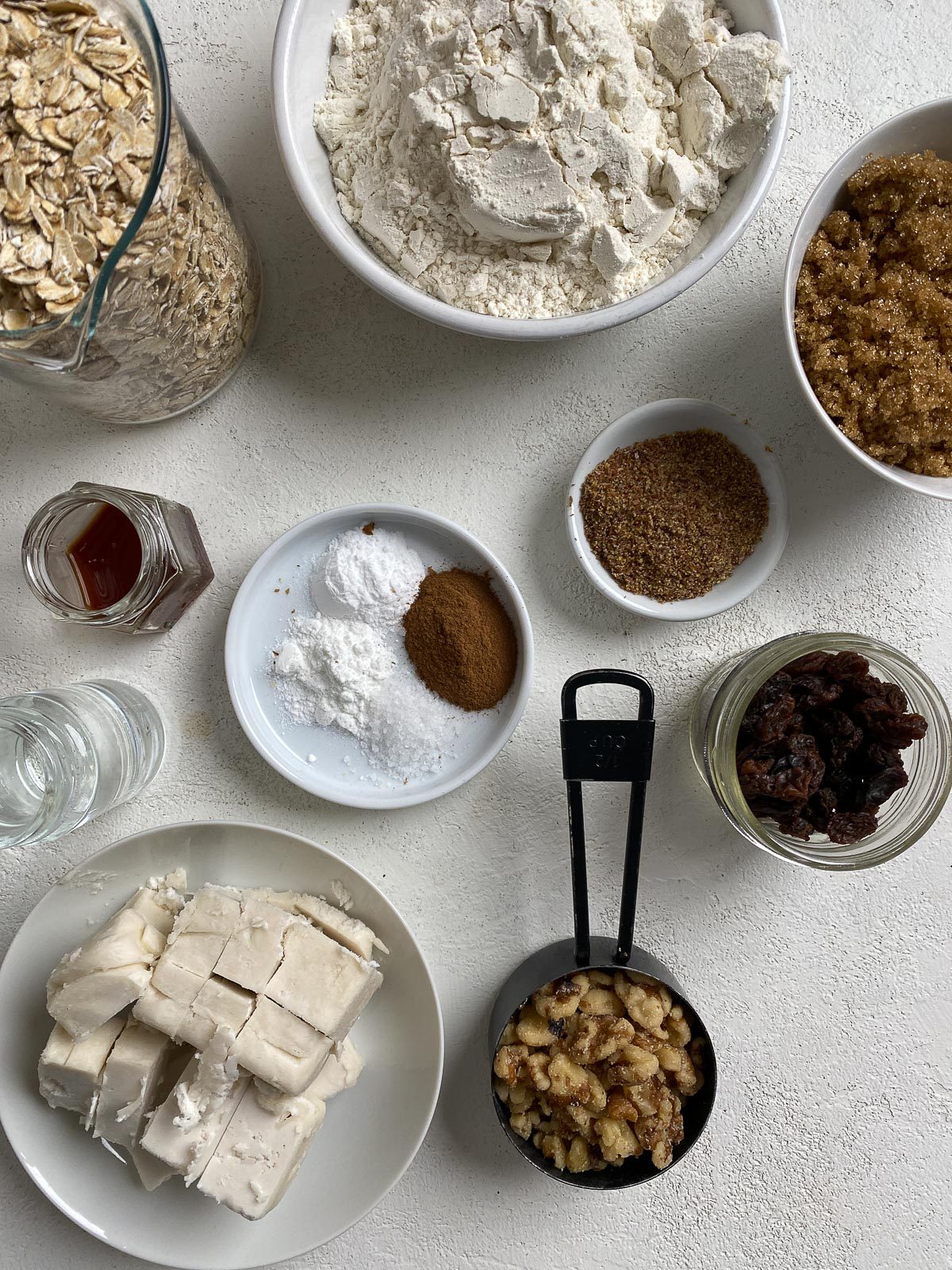 measured out ingredients for Vegan Oatmeal Cookies against a white surface