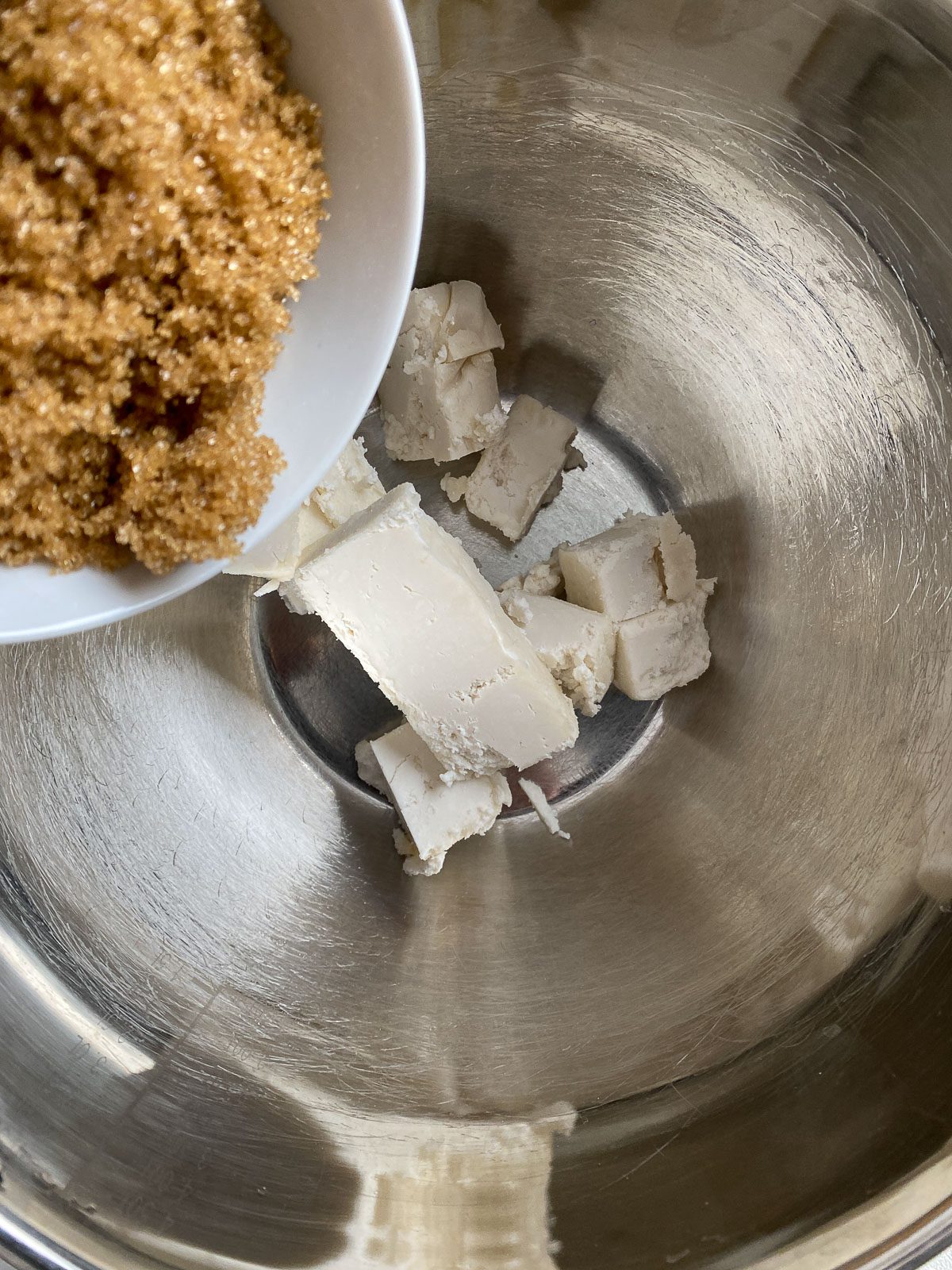 process of adding sugar to mixing bowl with butter