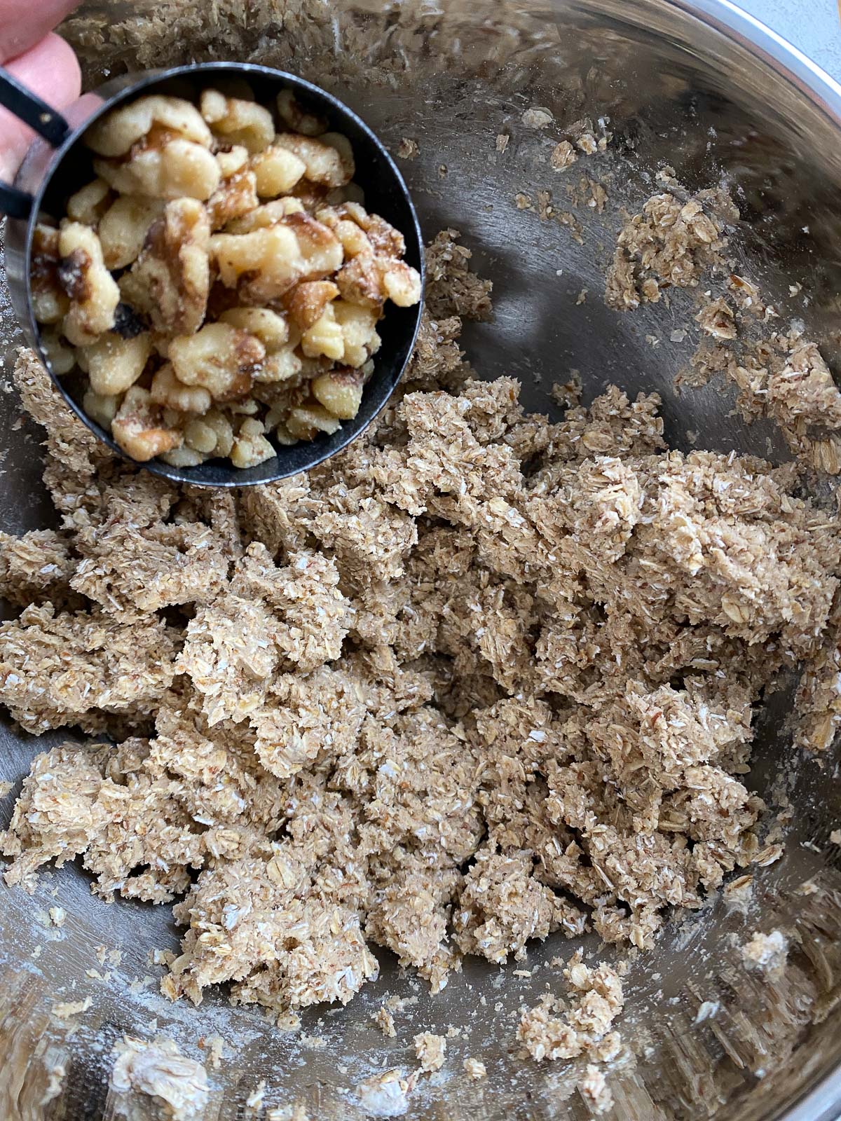 process shot of adding walnuts to mixing bowl