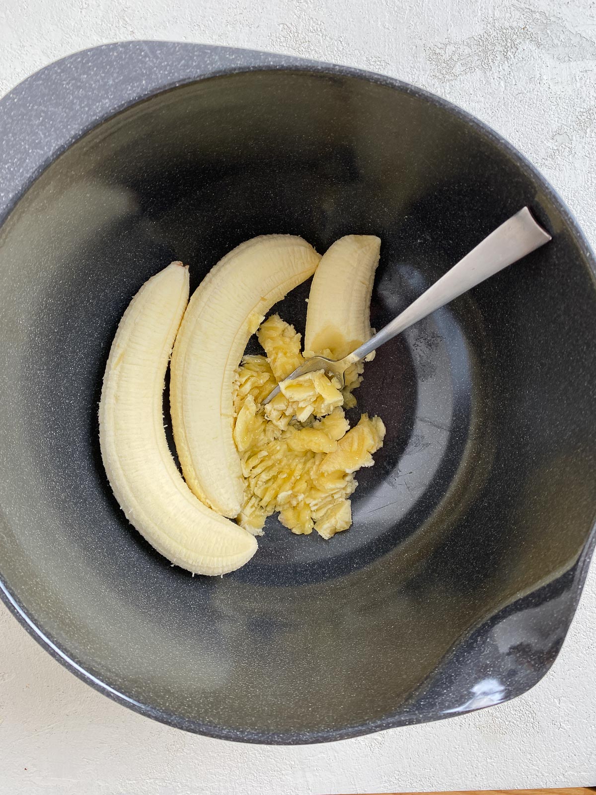 process of mashing bananas in bowl
