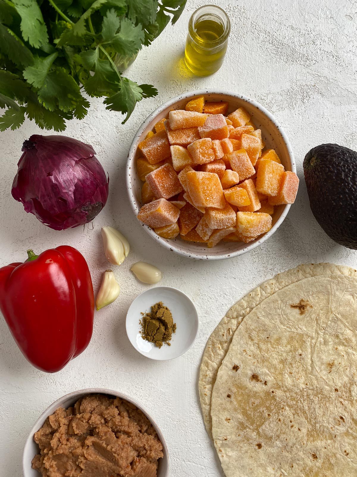 ingredients for butternut squash burrito measured out against a light surface