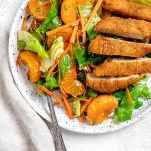 completed Vegan Asian Mandarin Chicken Ramen Noodle Salad on a white plate against a white background