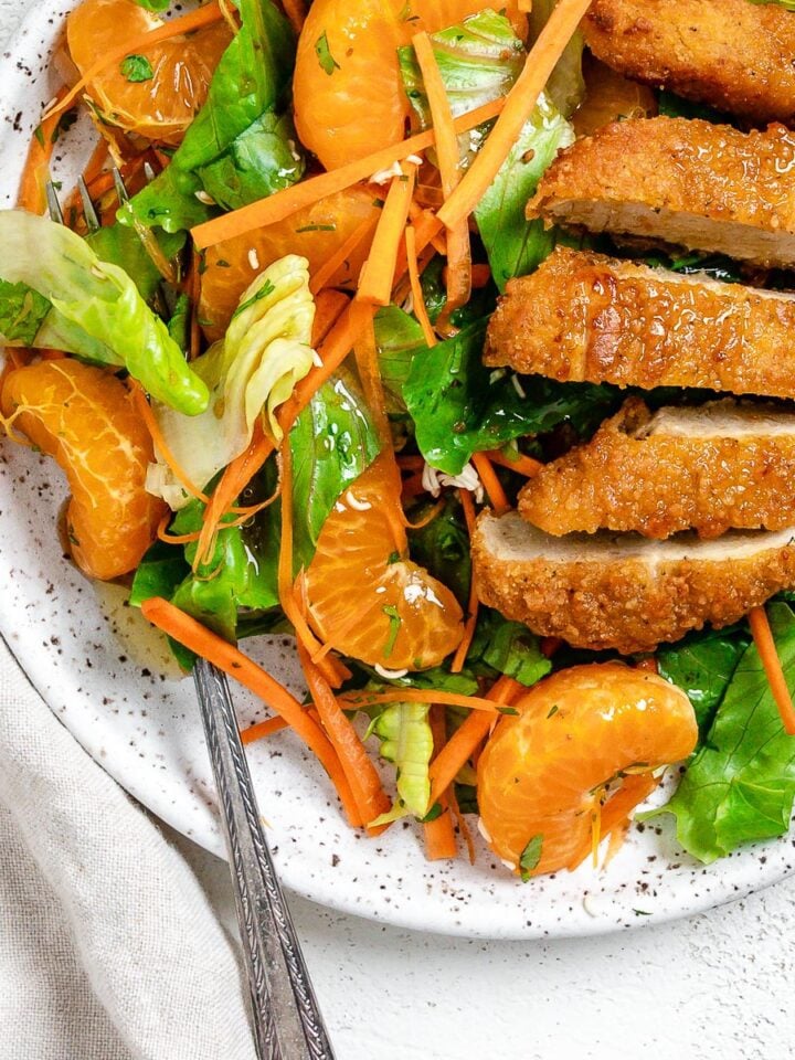 completed Vegan Asian Mandarin Chicken Ramen Noodle Salad on a white plate against a white background