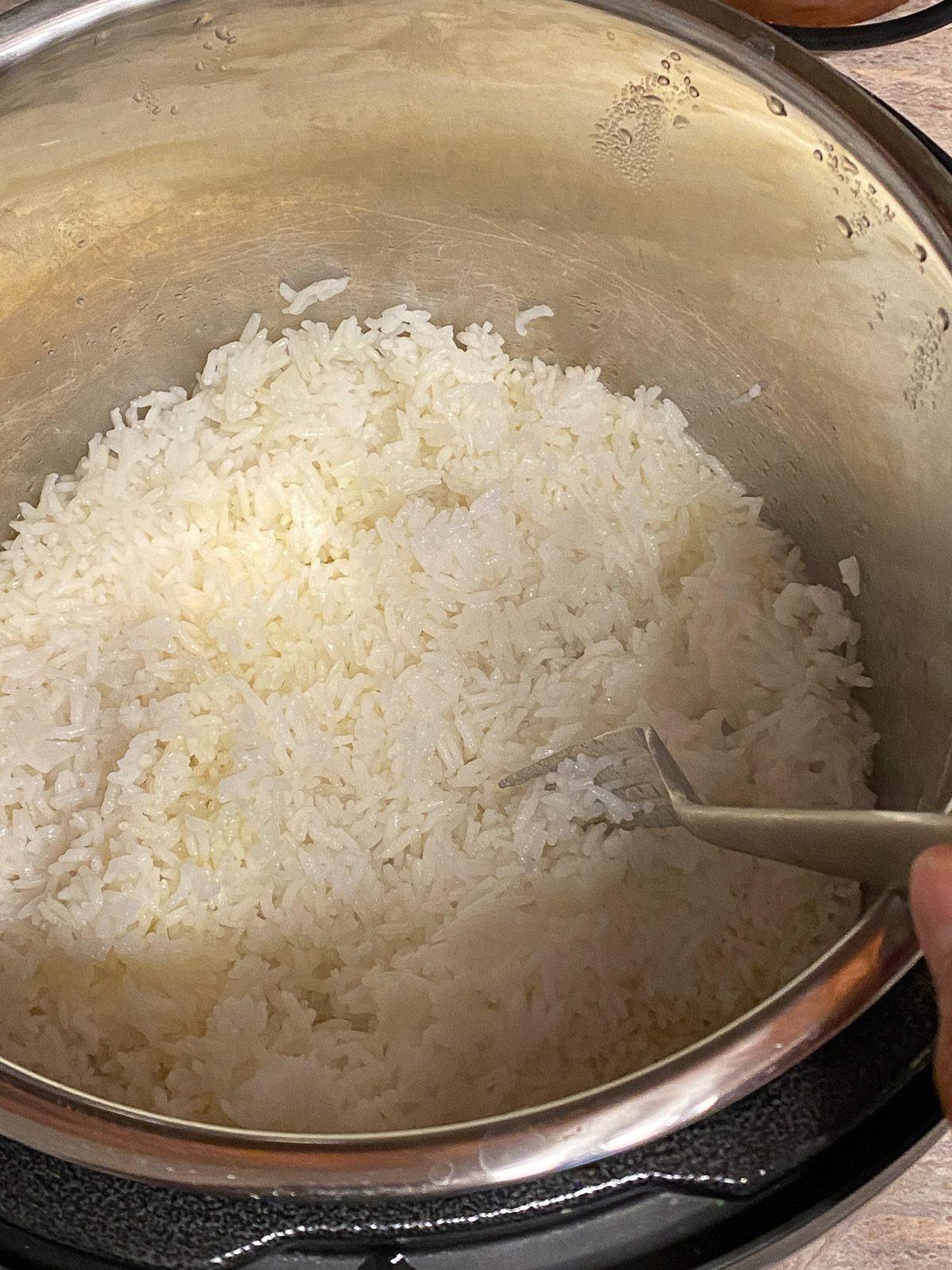 process shot post cooking and fluffing rice with utensil