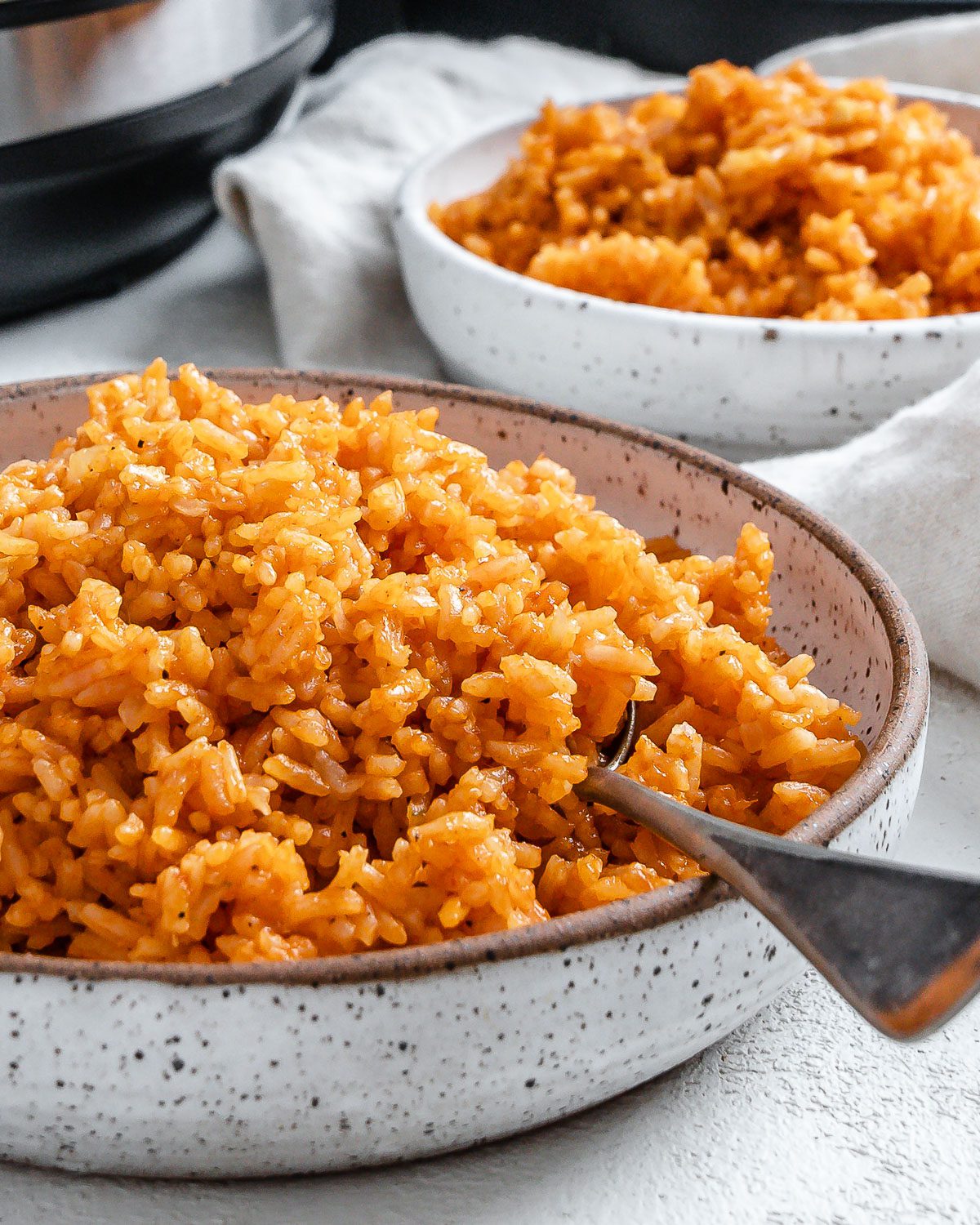 completed mexican rice in two white bowls against a white background
