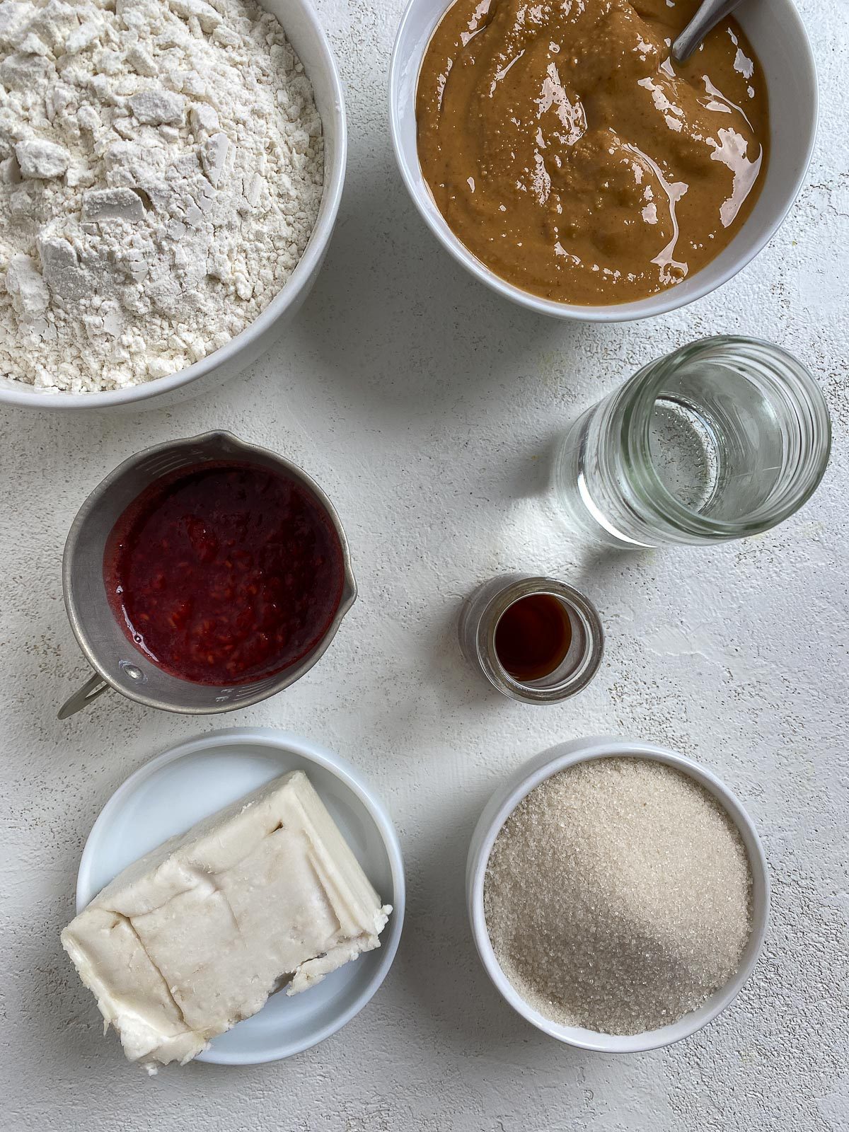 ingredients for Vegan Peanut Butter and Jelly Thumbprint Cookies measured out against a white surface