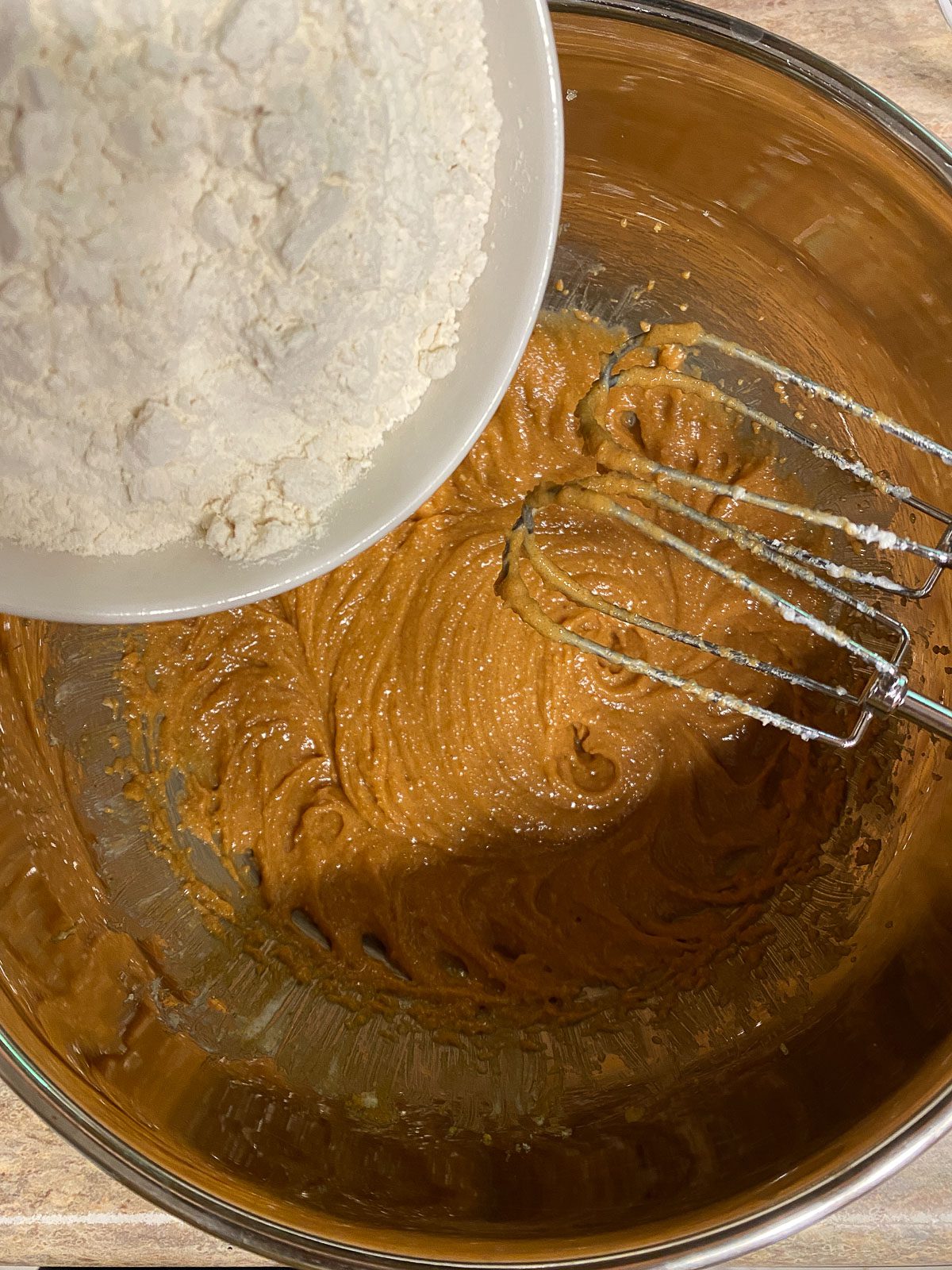 process of adding flour to mixture in bowl