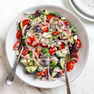 completed Vegan Greek Salad on a white plate against a white background
