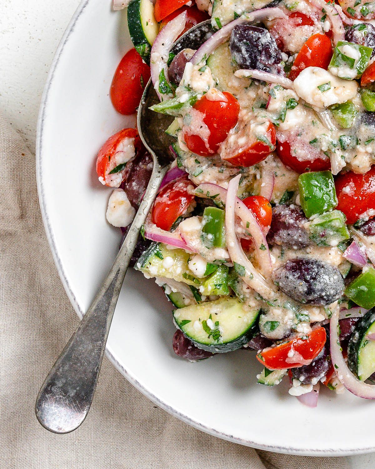 completed Vegan Greek Salad on a white plate against a white background