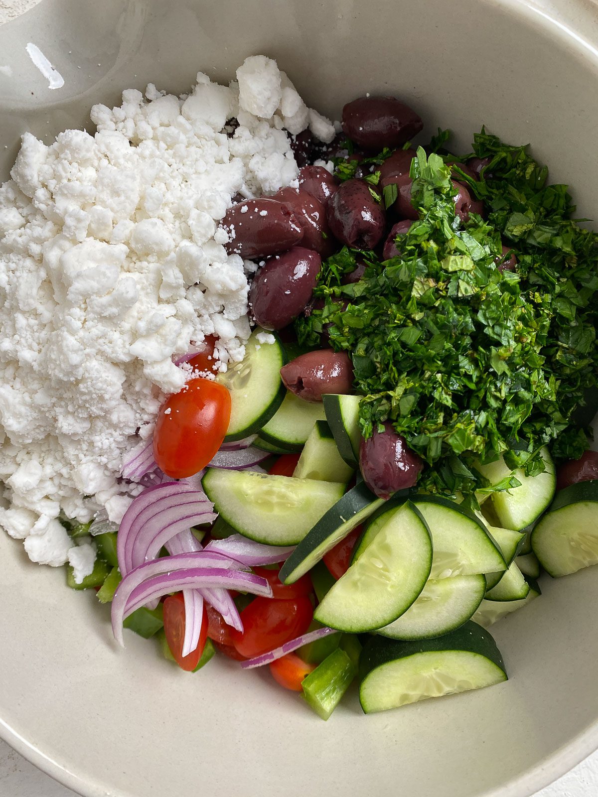 Vegan Greek Salad ingredients added to bowl