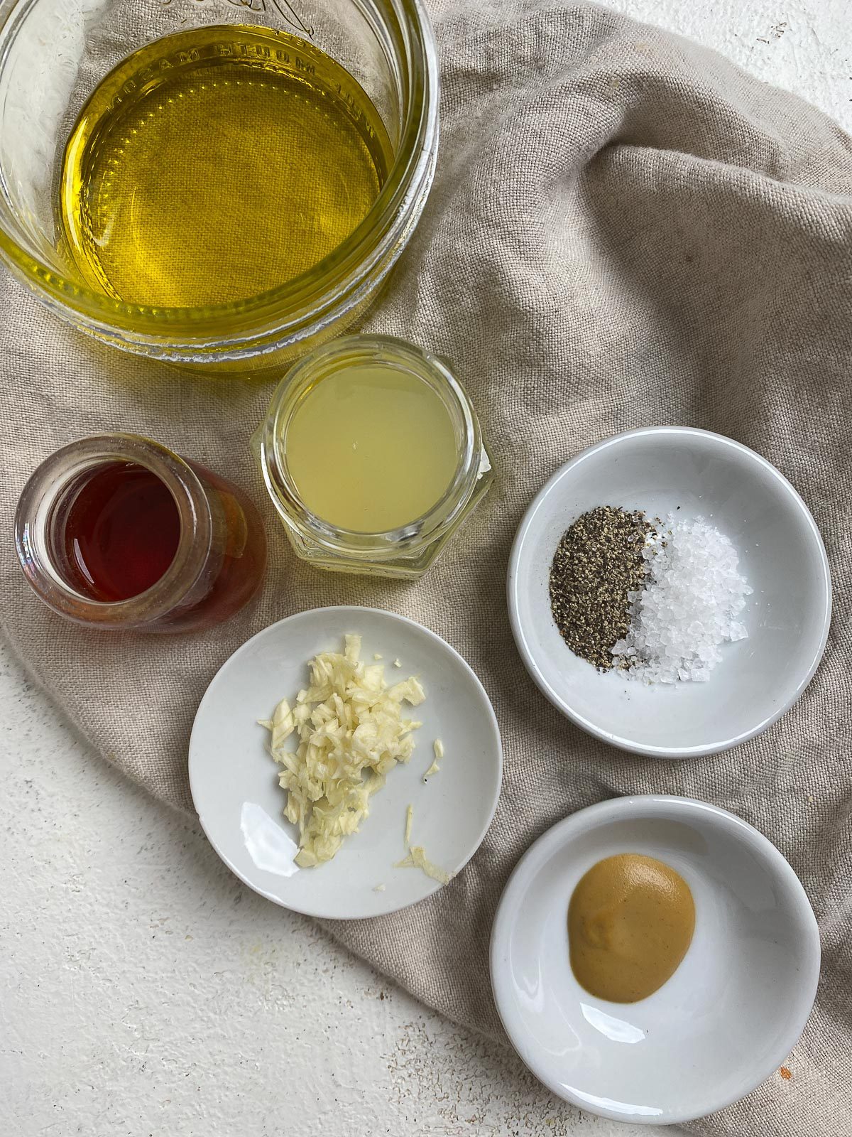 Vegan Greek Salad dressing ingredients measured out in individual bowls against a light surface