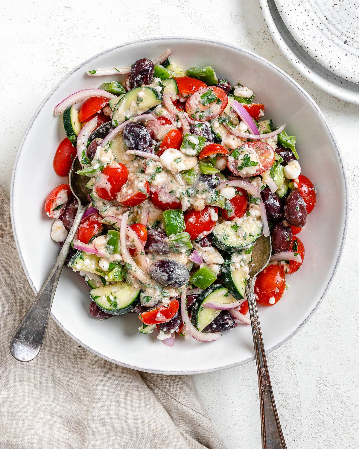 completed Vegan Greek Salad on a white plate against a white background