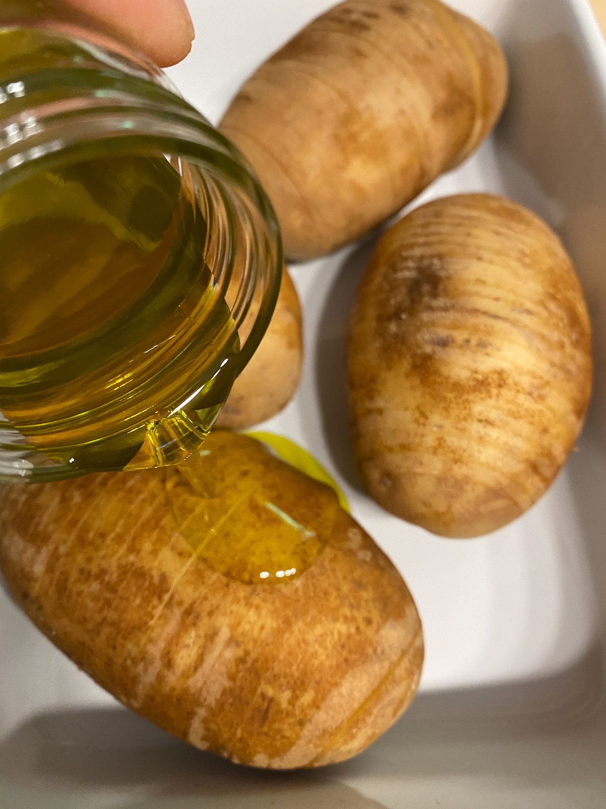 process of pouring oil onto potatoes