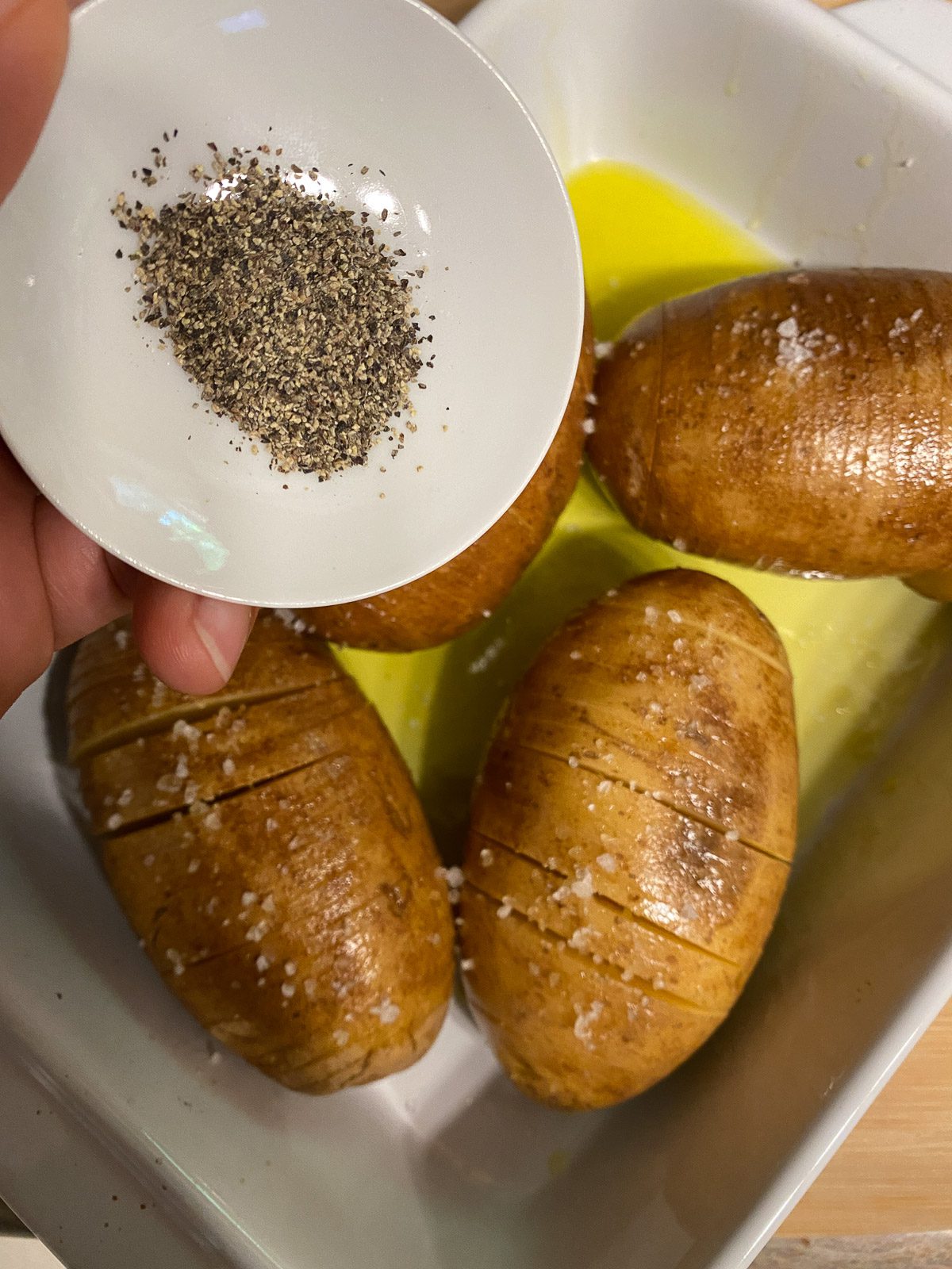process of pouring pepper onto potatoes