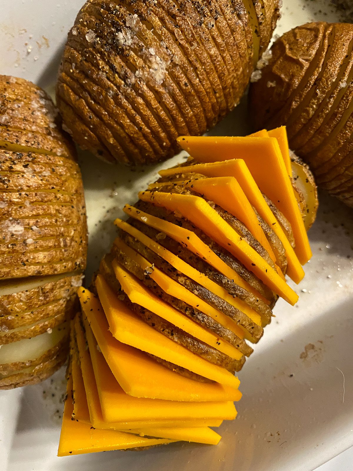 process of adding triangular cheese slices to potatoes