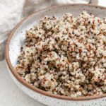 completed Pressure Cooker Quinoa in a white bowl against a white background