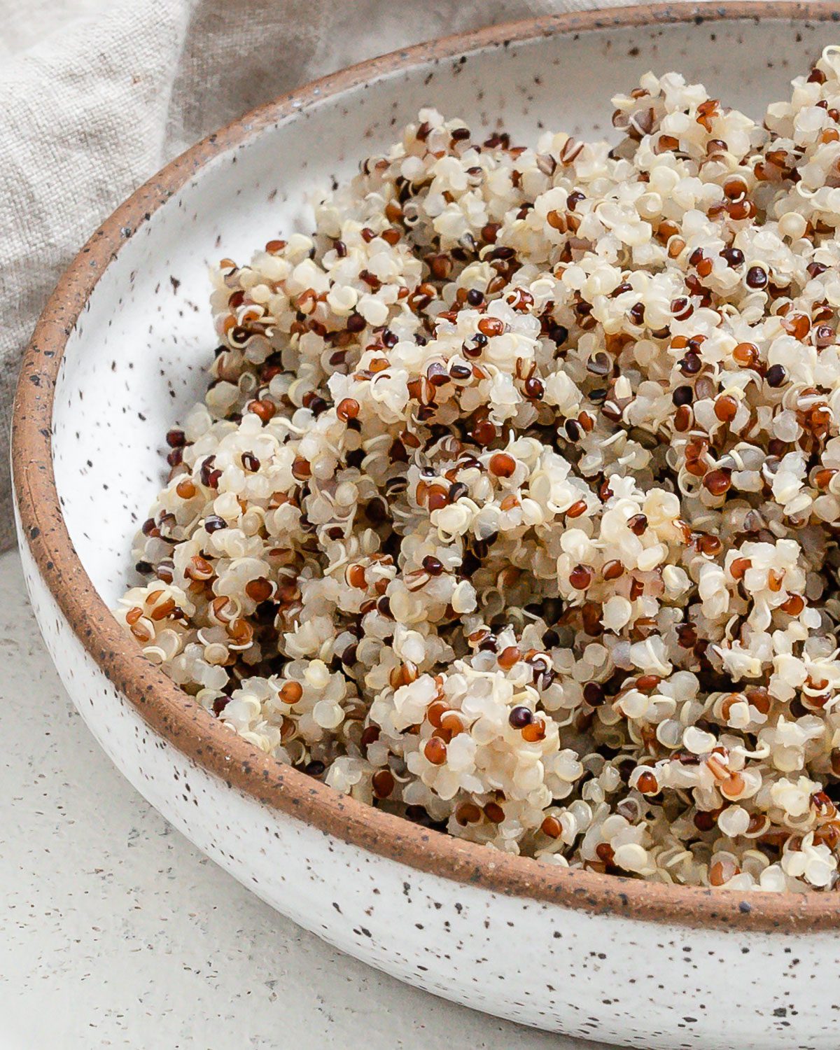 completed Pressure Cooker Quinoa in a white bowl against a white background
