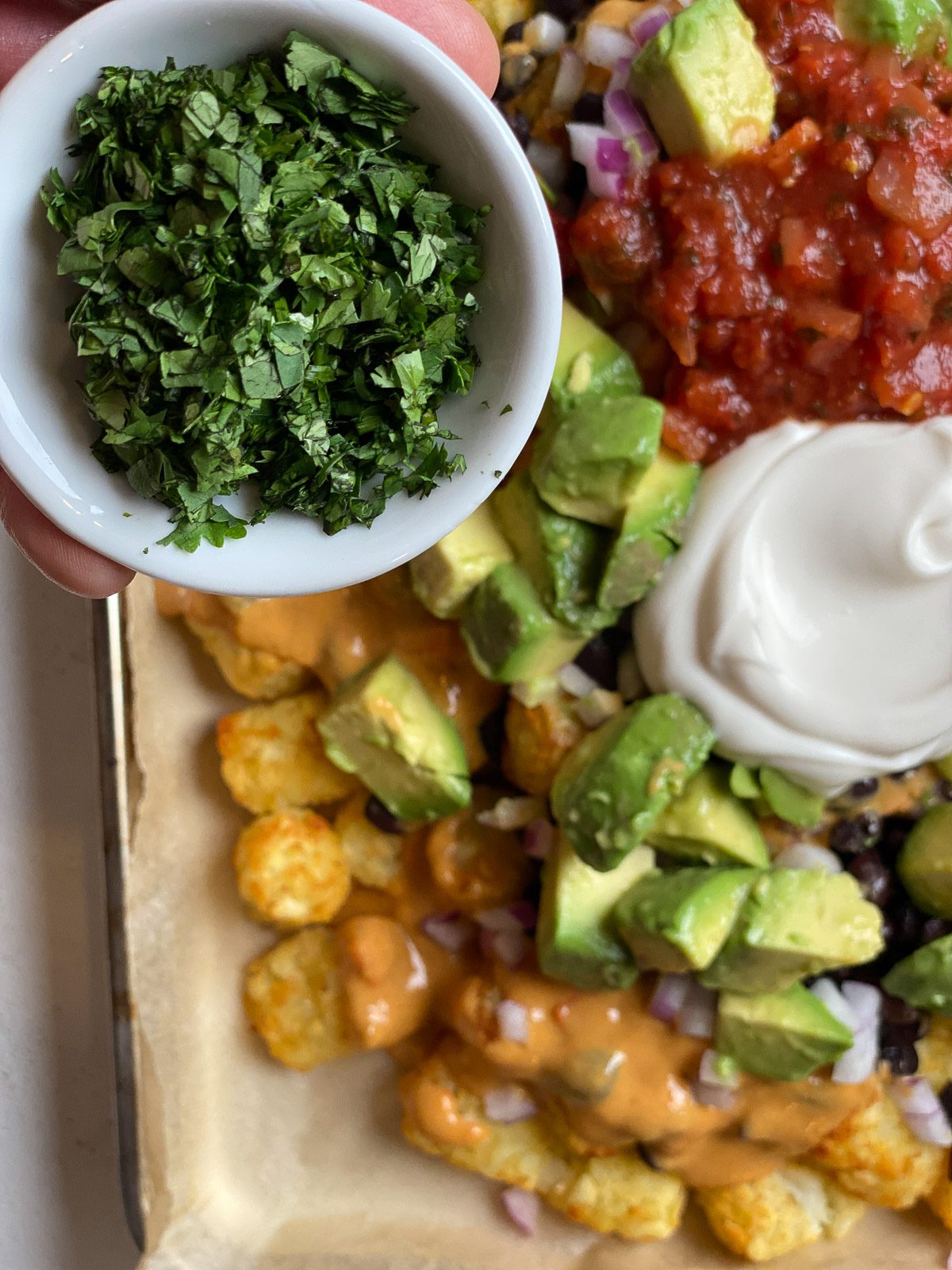 process of adding cilantro to totchos