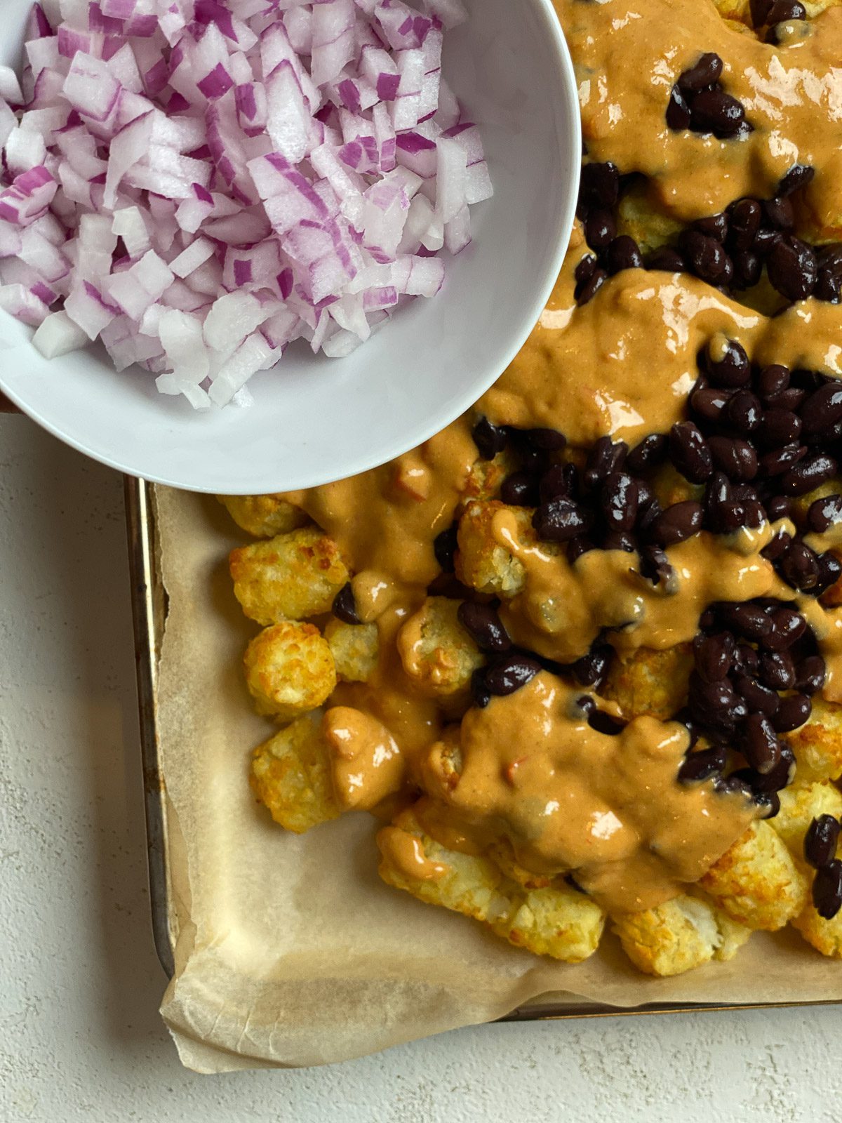 process of adding diced onion to totchos
