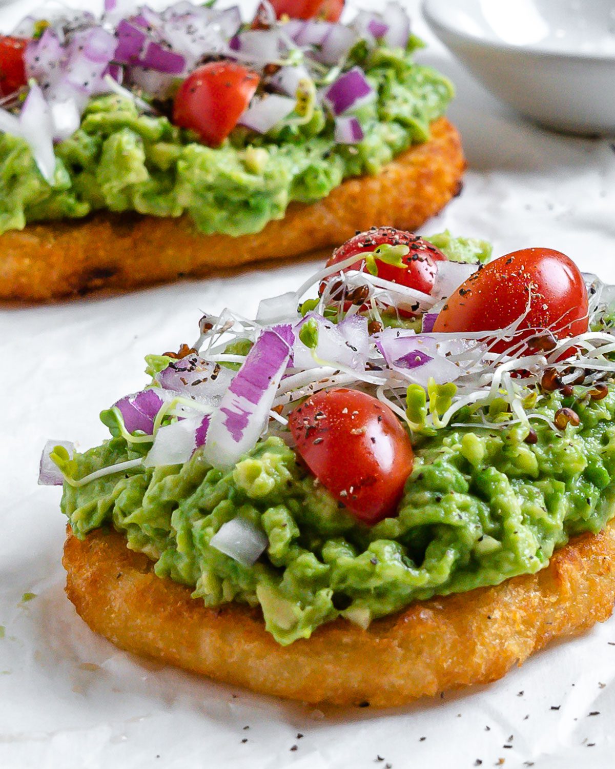 two completed pieces of Smashed Avocado Hashbrown Toast