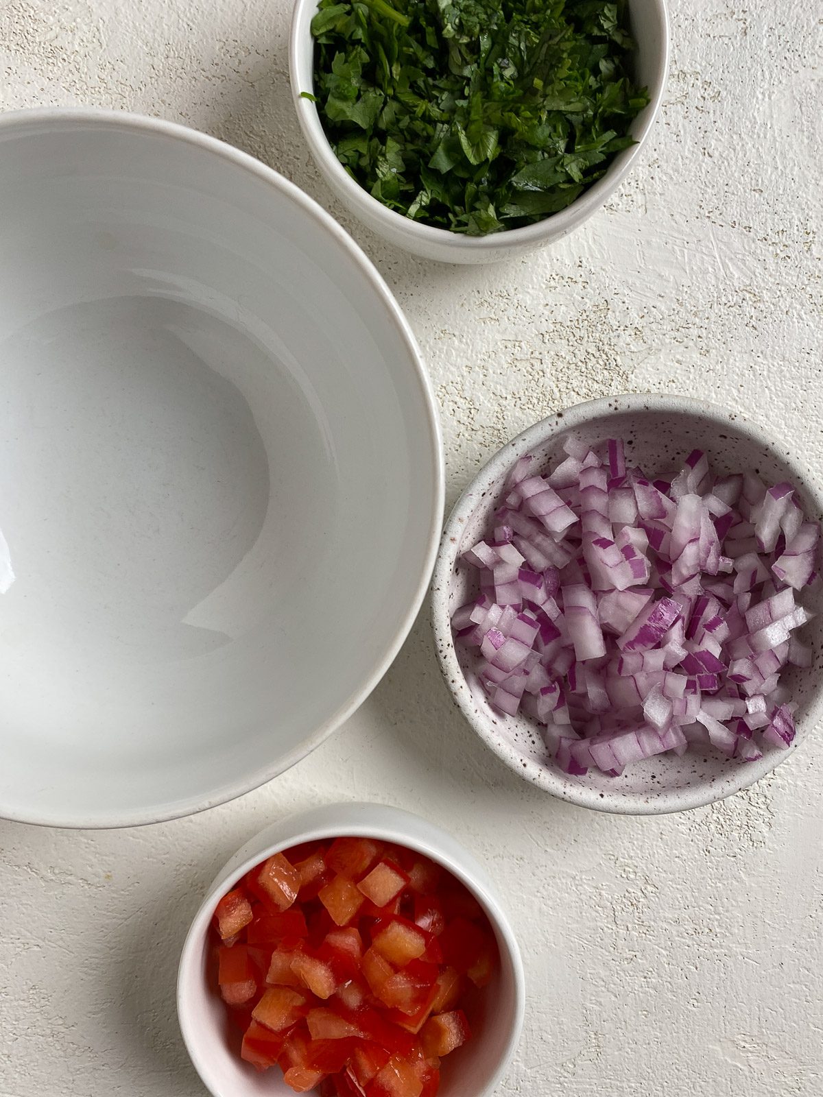 ingredients for Vegan Bean Tostadas measured out in bowls against a white background alongside a white bowl