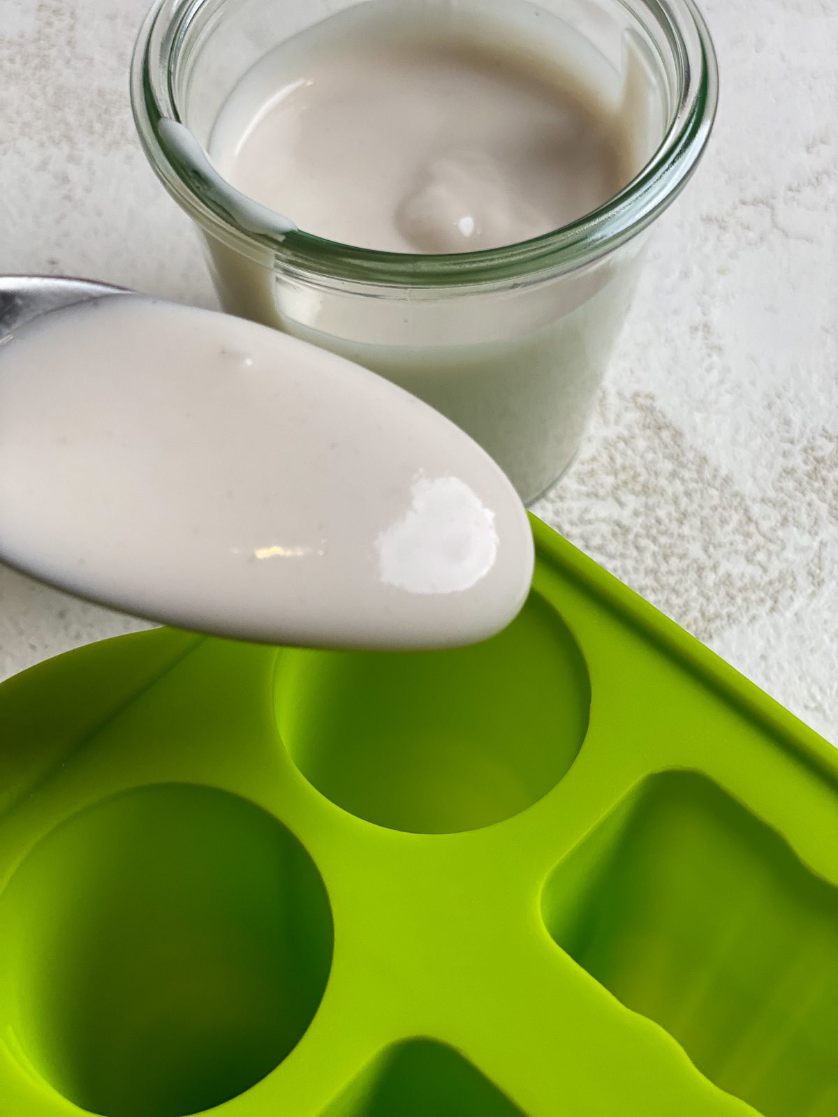 process of adding yogurt to popsicle molds