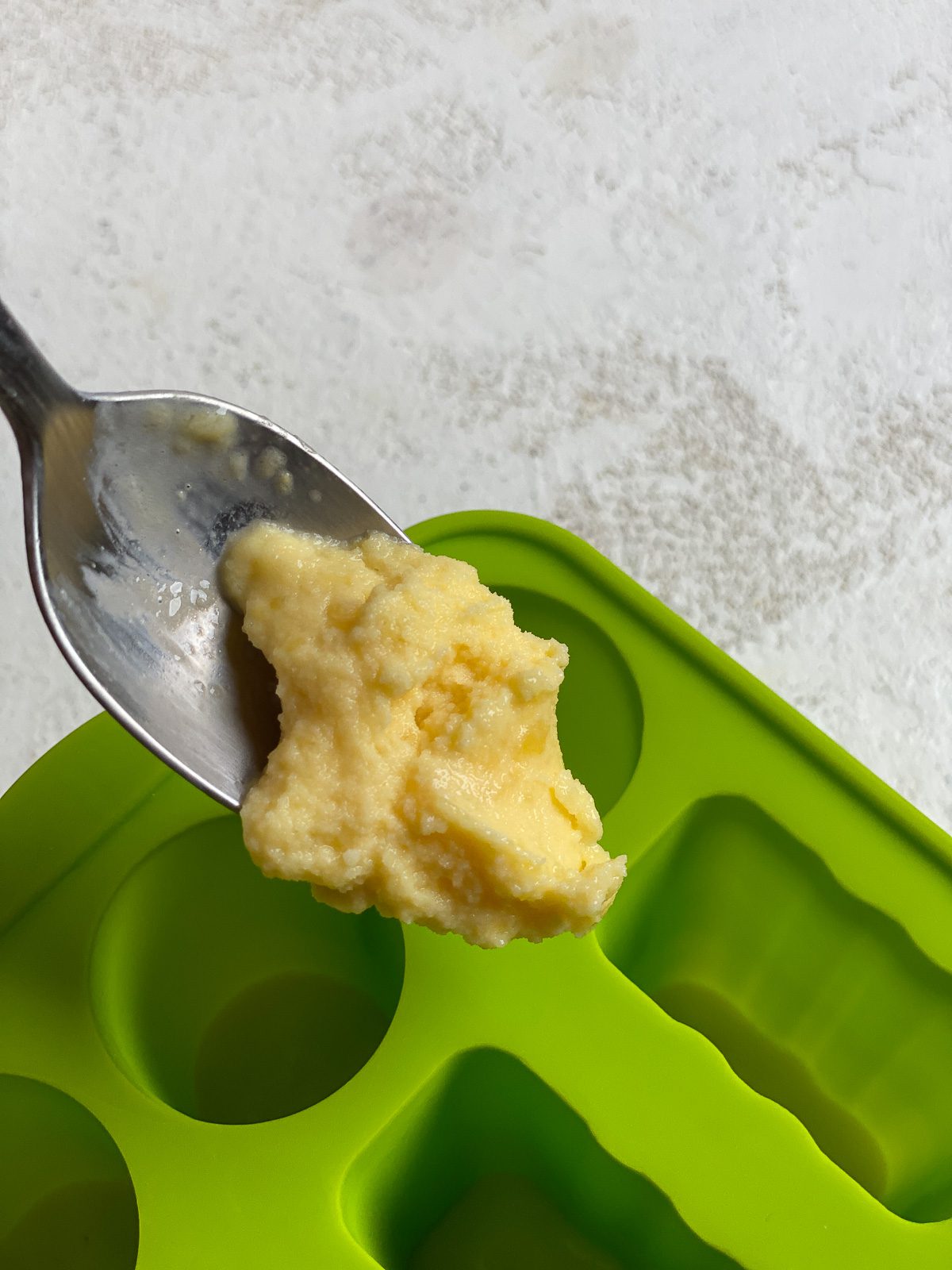 process of adding mango mixture to popsicle mold