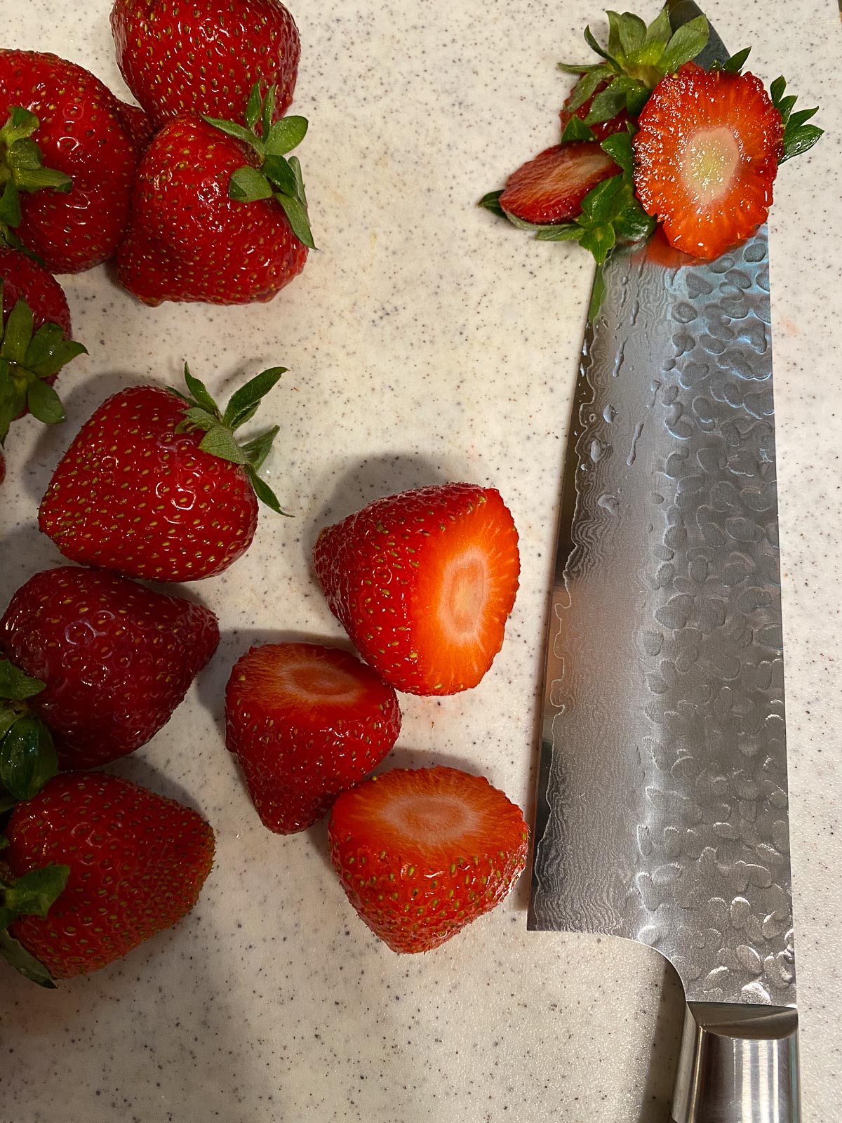 process of cutting strawberries alongside a knife