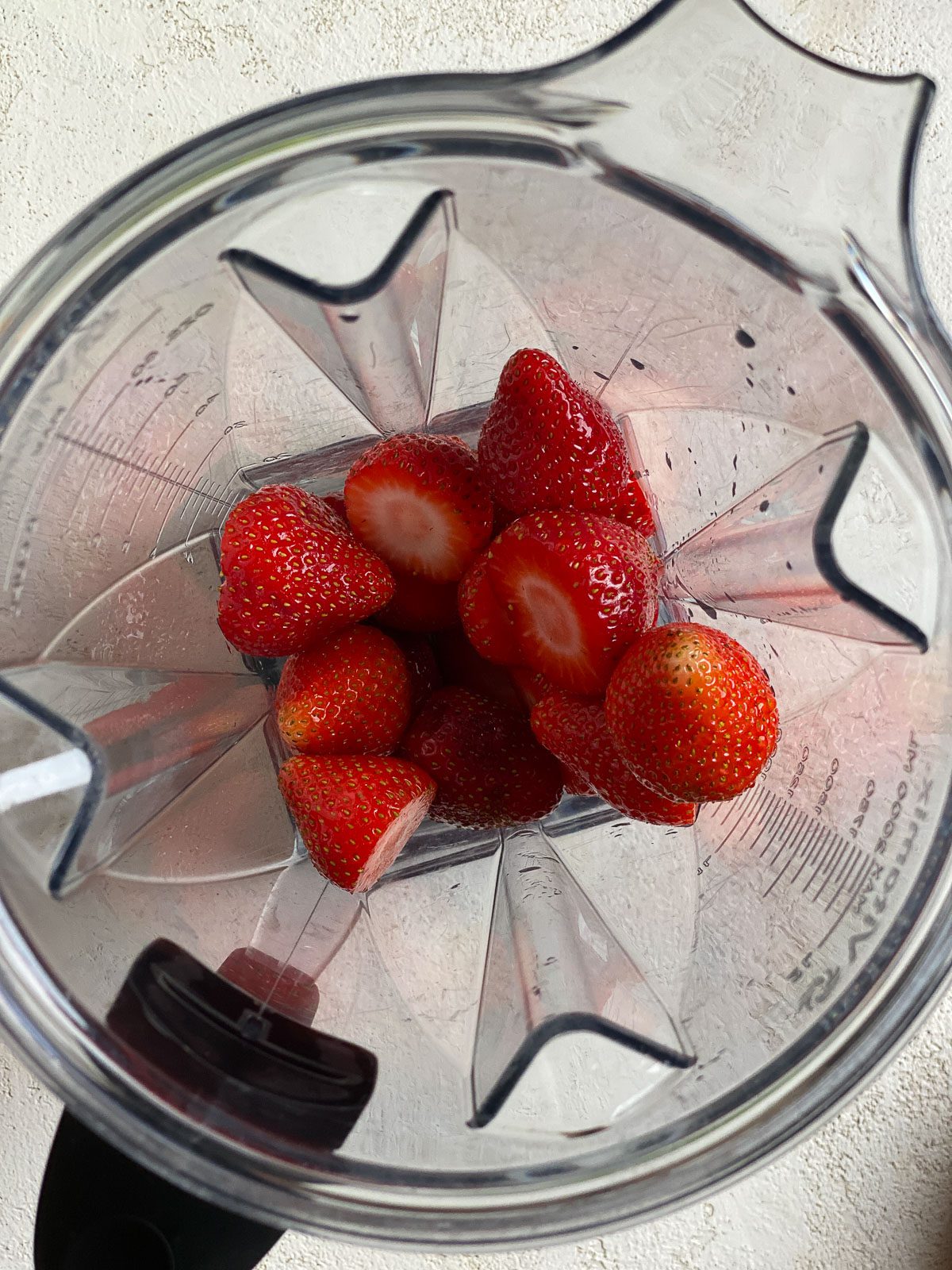 process of adding strawberries in a food processor