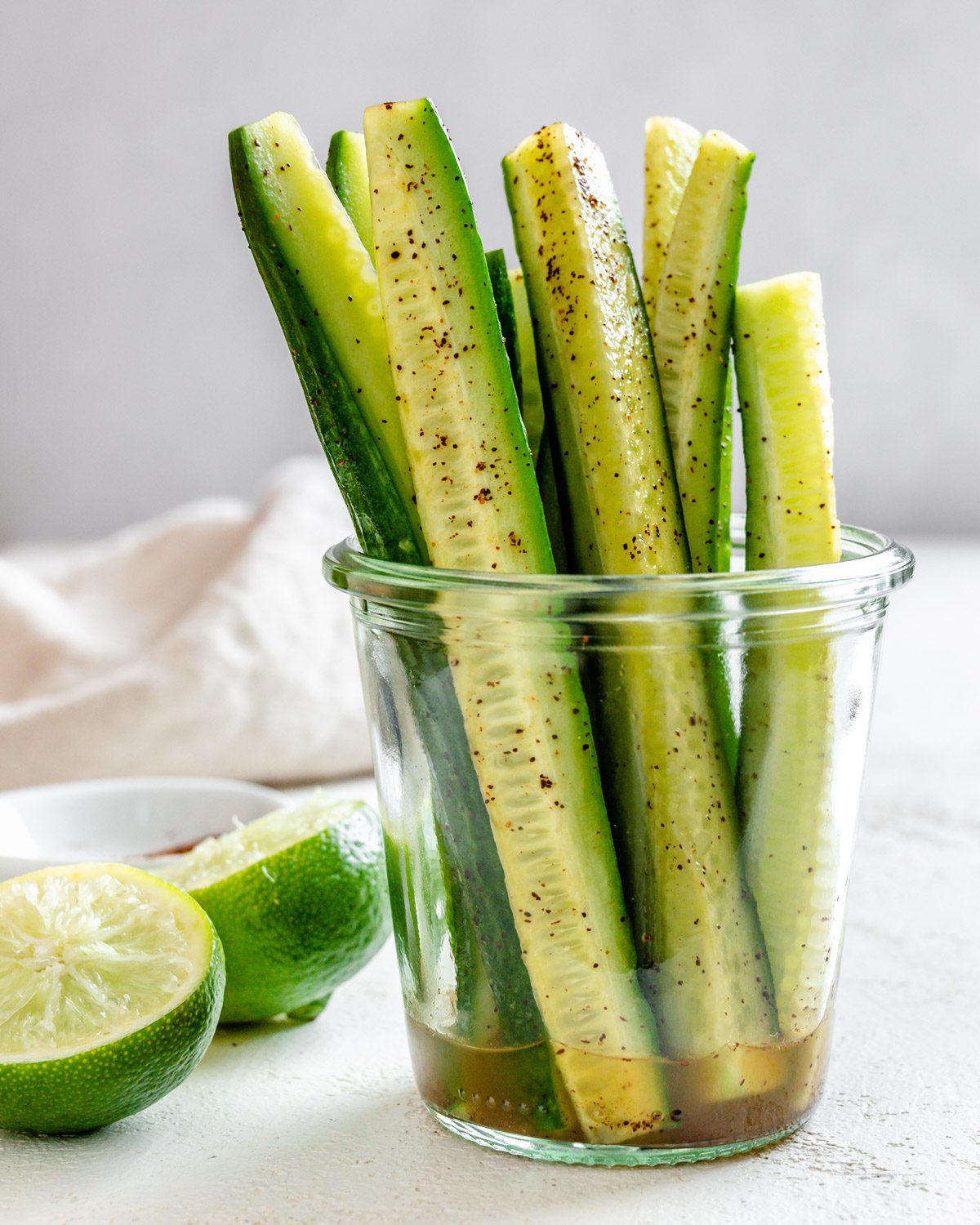 completed Cucumbers with Tajin in a clear glass against a light background