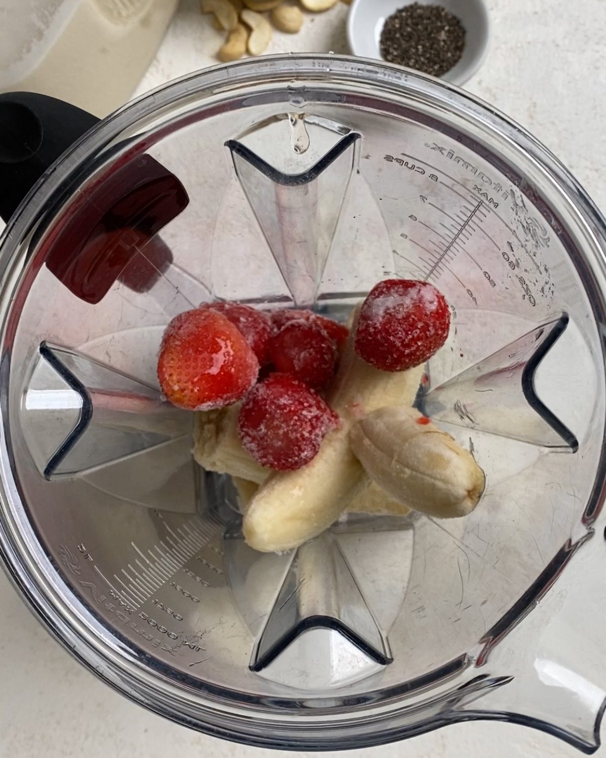 process of adding strawberries to blender